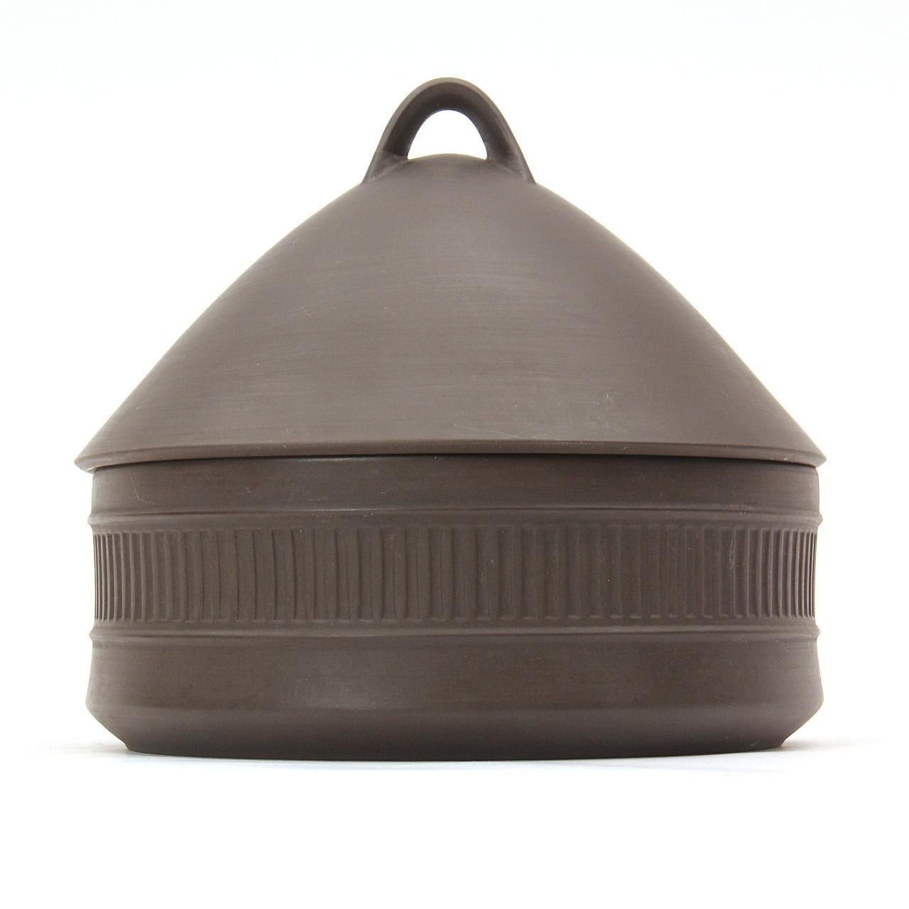 A flame stone ceramic casserole pot with a domed lid, matte exterior and cream glazed interior.