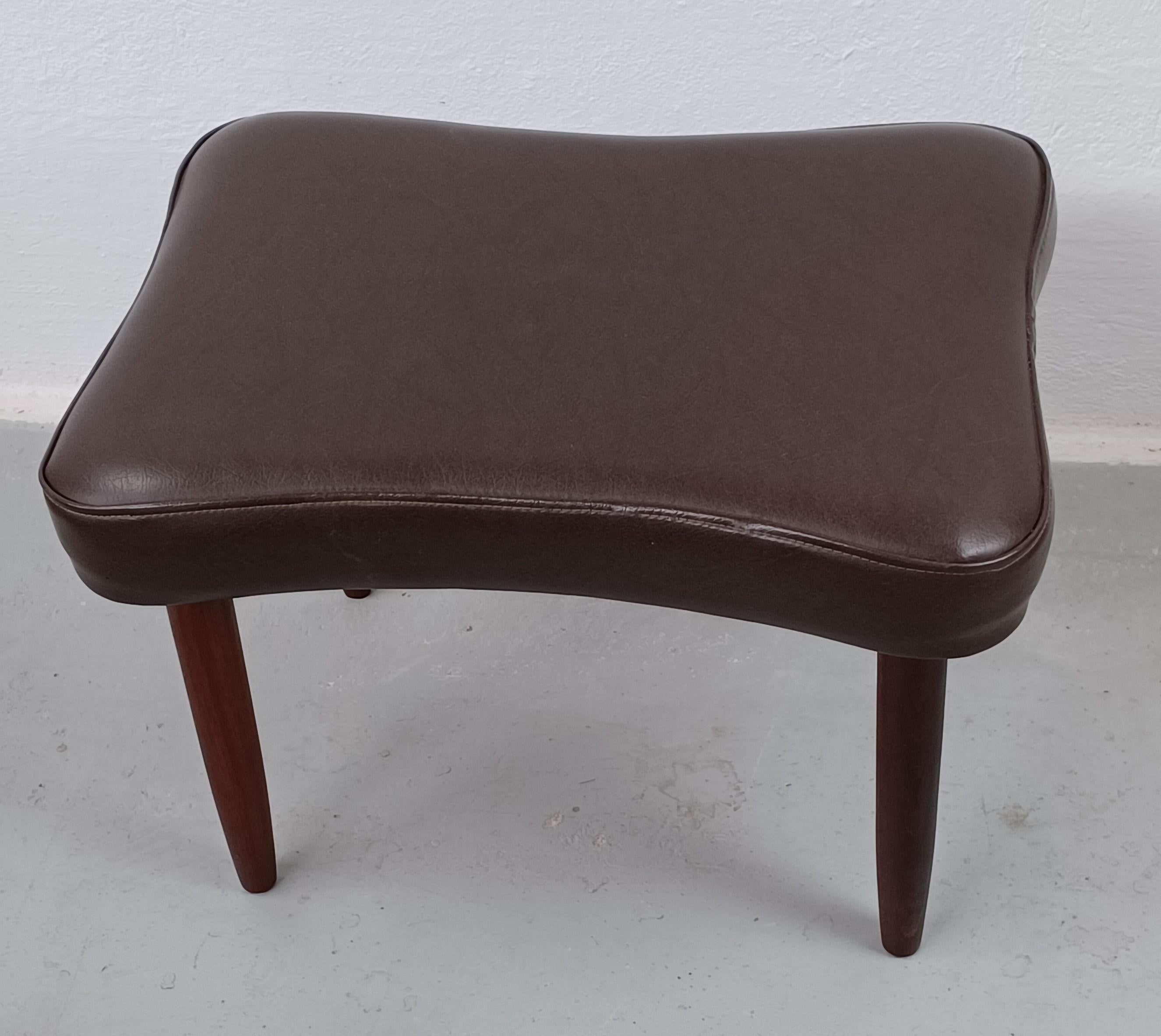 1960s Danish footstool in teak and faux leather manufactored by Capri

Danish midcentury footstool with elegant organic shaped seat upholstered in brown faux leather and legs in solid teak.

The footstool is in good vintage condition and has been