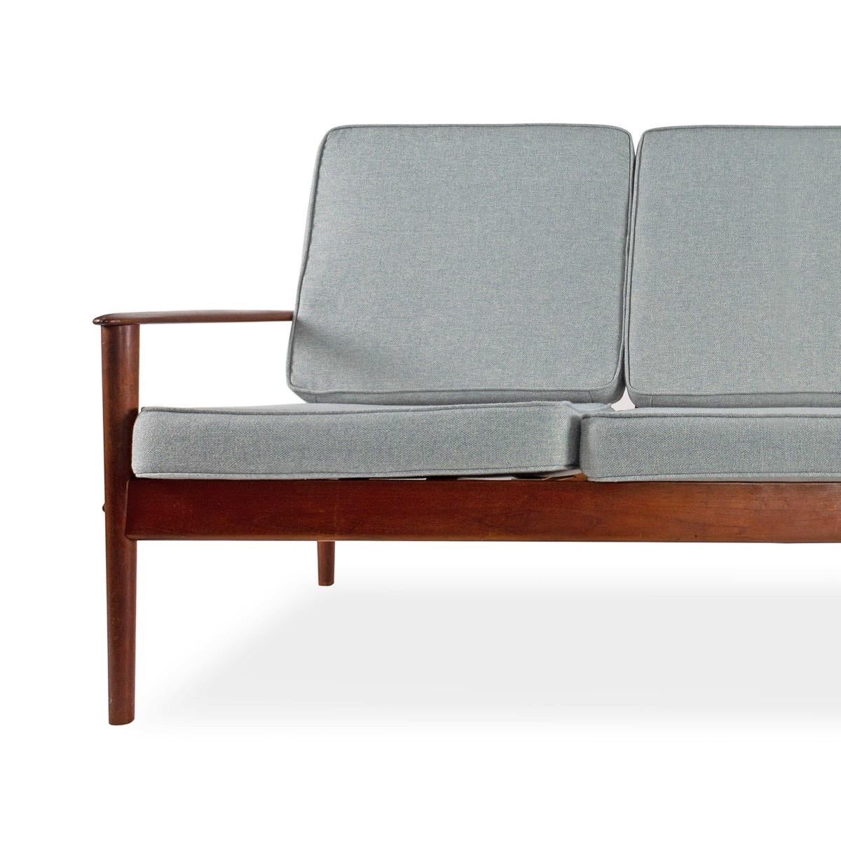 A three-seat teak-framed sofa with newly re-upholstered seat and back cushions, Denmark, circa 1960. Signed.

Gray fabric.

Dimensions: 70
