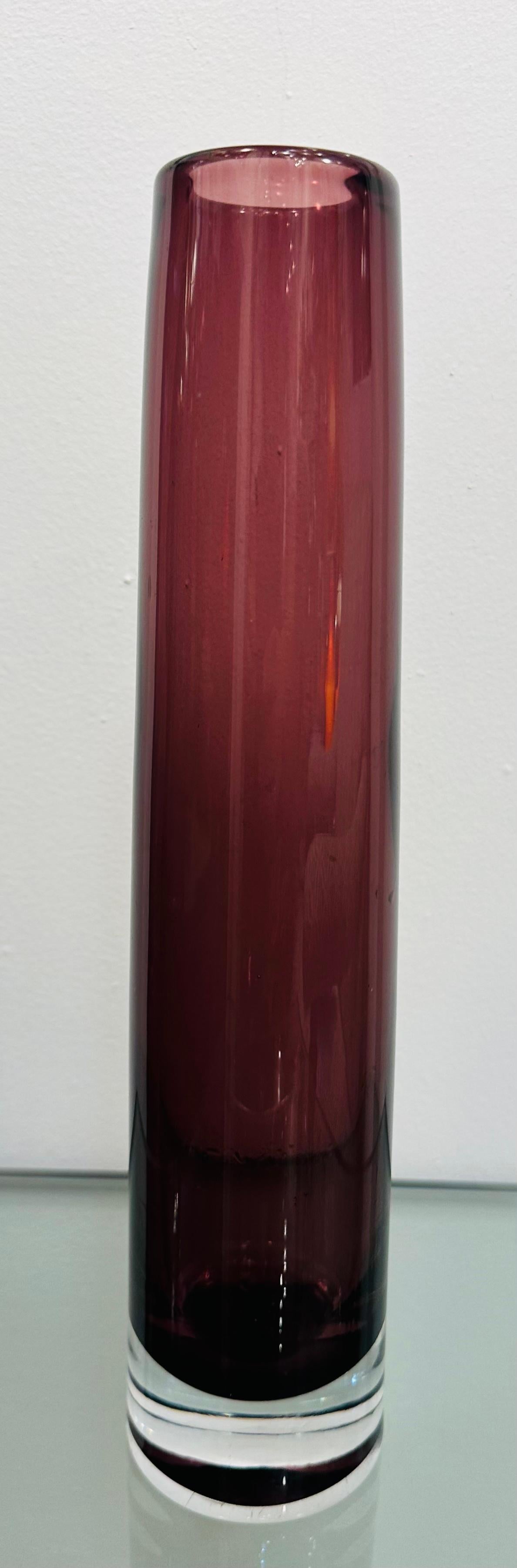 Vaso conico rotondo in vetro trasparente e viola soffiato a mano del 1960.  La base è in vetro trasparente che contrasta con il viola della parte superiore.  Non è presente alcun timbro o iscrizione del produttore.  Perfetto per un piccolo mazzo di