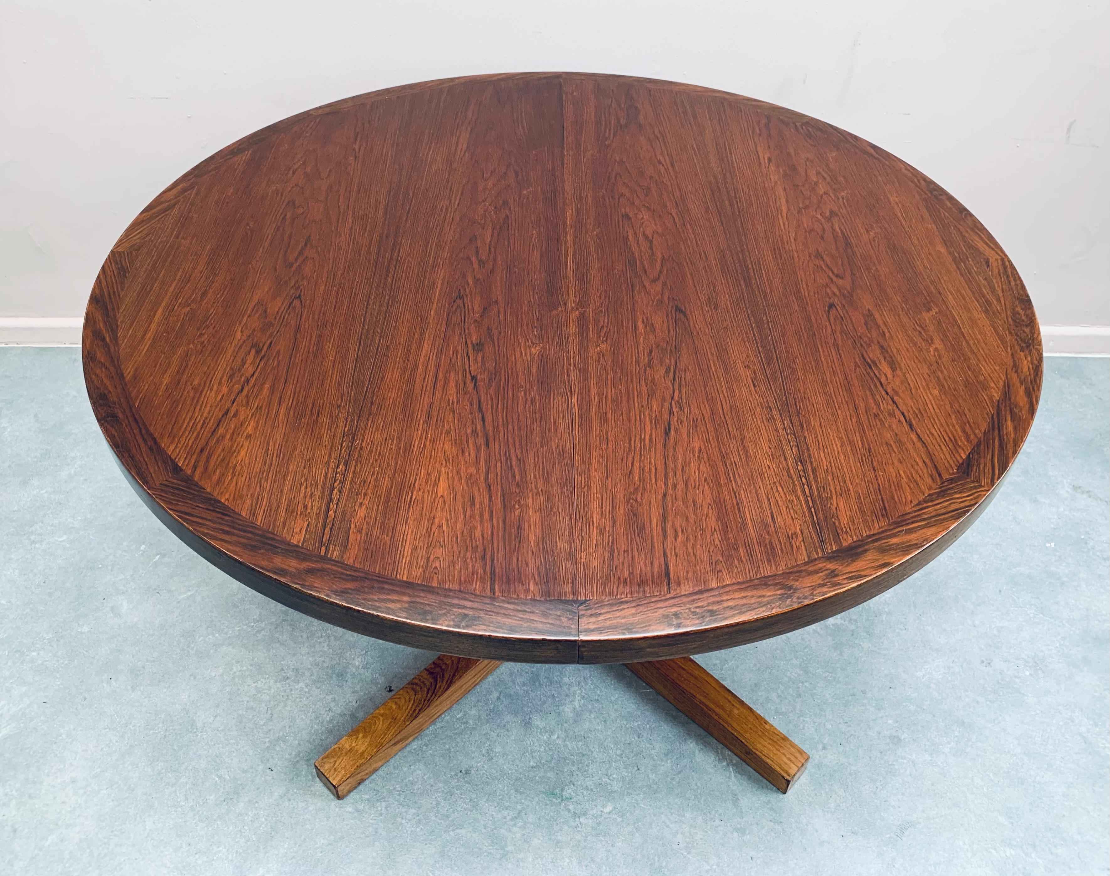 A stunning 1960s Rosewood pedestal dining table with a wonderful deep grain patina. Made in Denmark and designed by John Mortensen for Heltborg Mobler. The table sits on a central pedestal base with two independent extension leaves which require