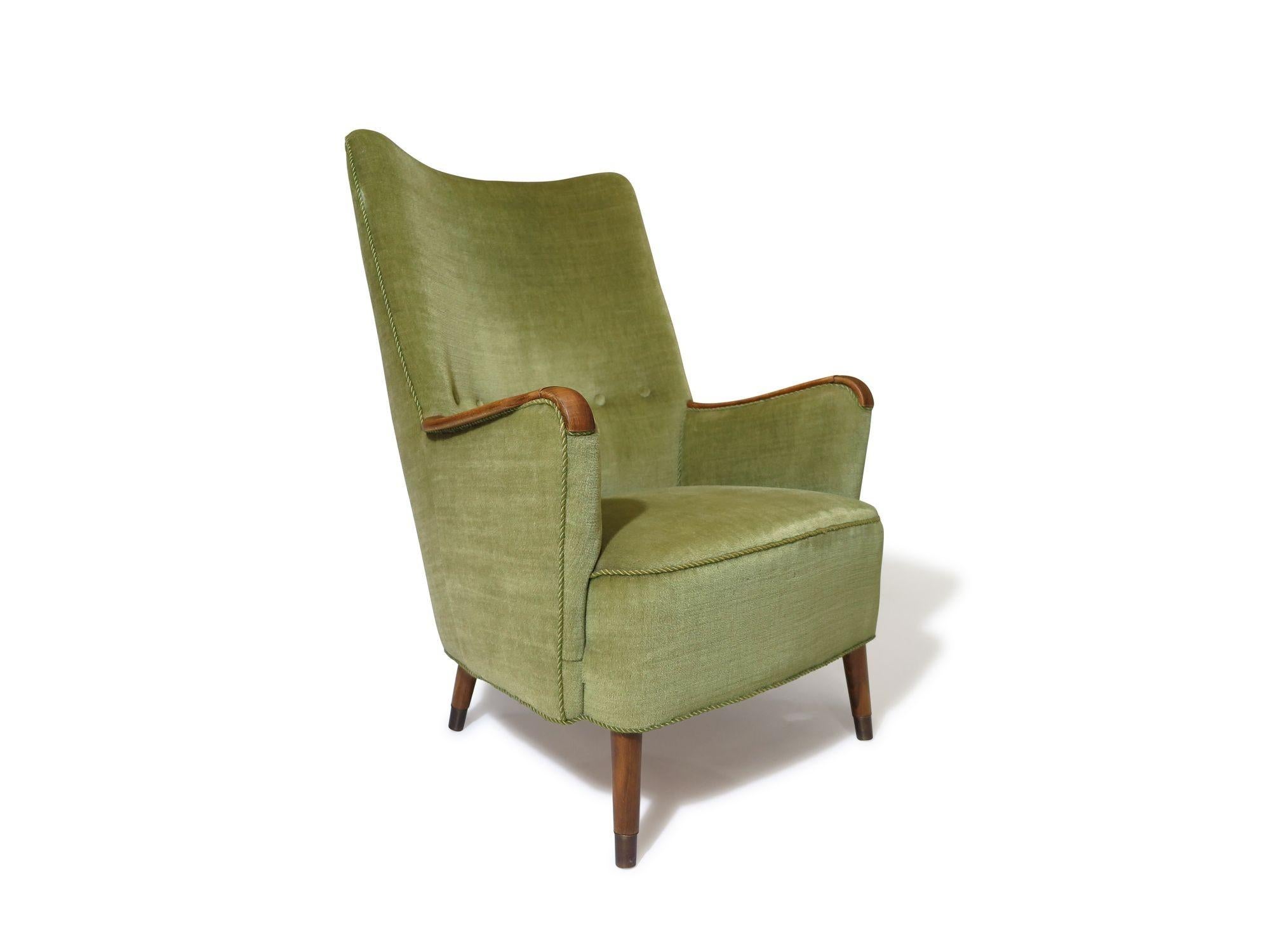 1960s Danish high-back lounge chair crafted a solid wood frame with hand-tied spring seat, upholstered in its original green mohair fabric. The button tufted back and wooden armrest add to its charm, providing excellent back support and comfortable
