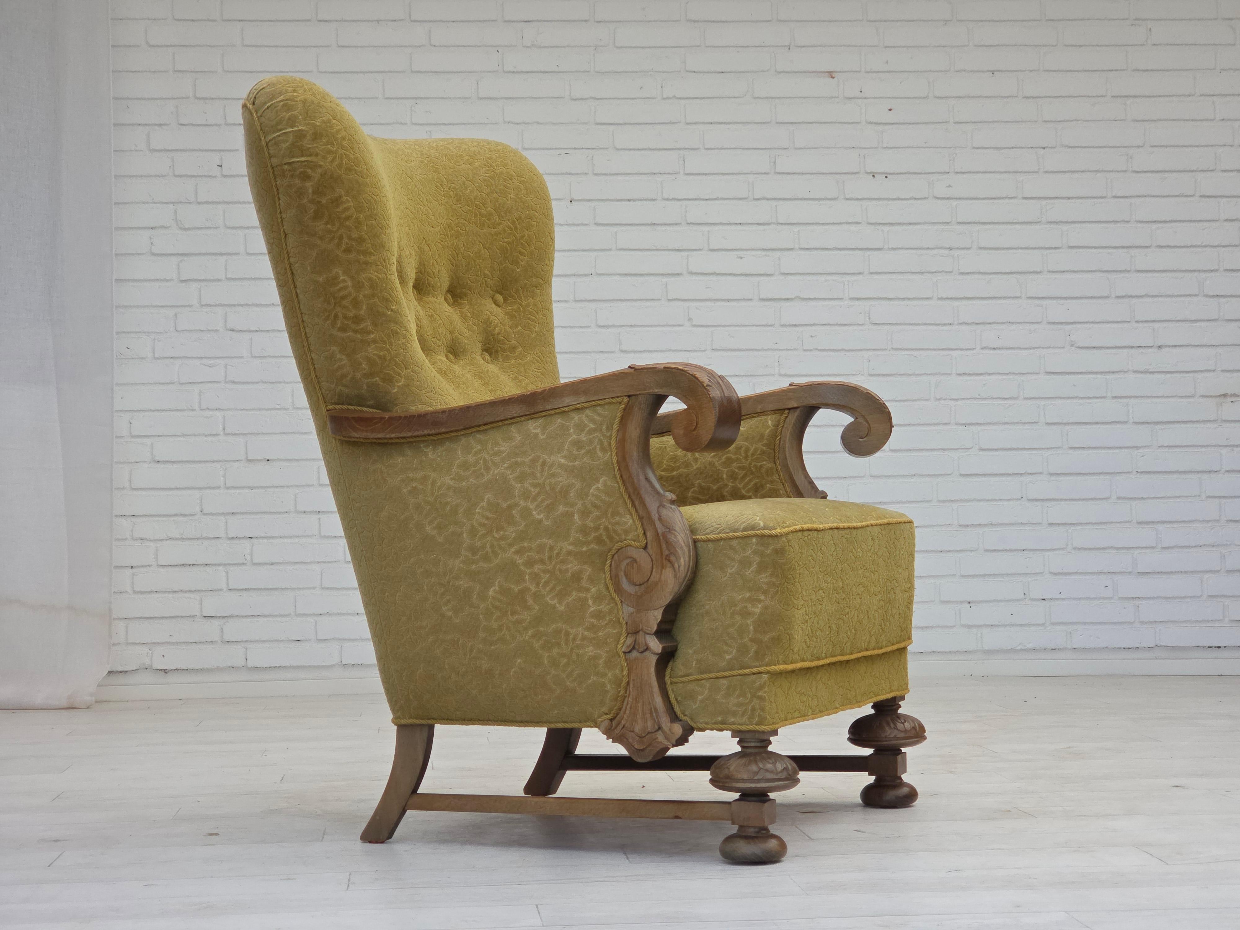 Poltrona danese con schienale alto degli anni '1960. Tessuto originale in cotone/lana di colore verde, legno massiccio di quercia, molle nella seduta. Prodotto da un produttore di mobili danese intorno agli anni 1955-60. Condizioni originali buone: