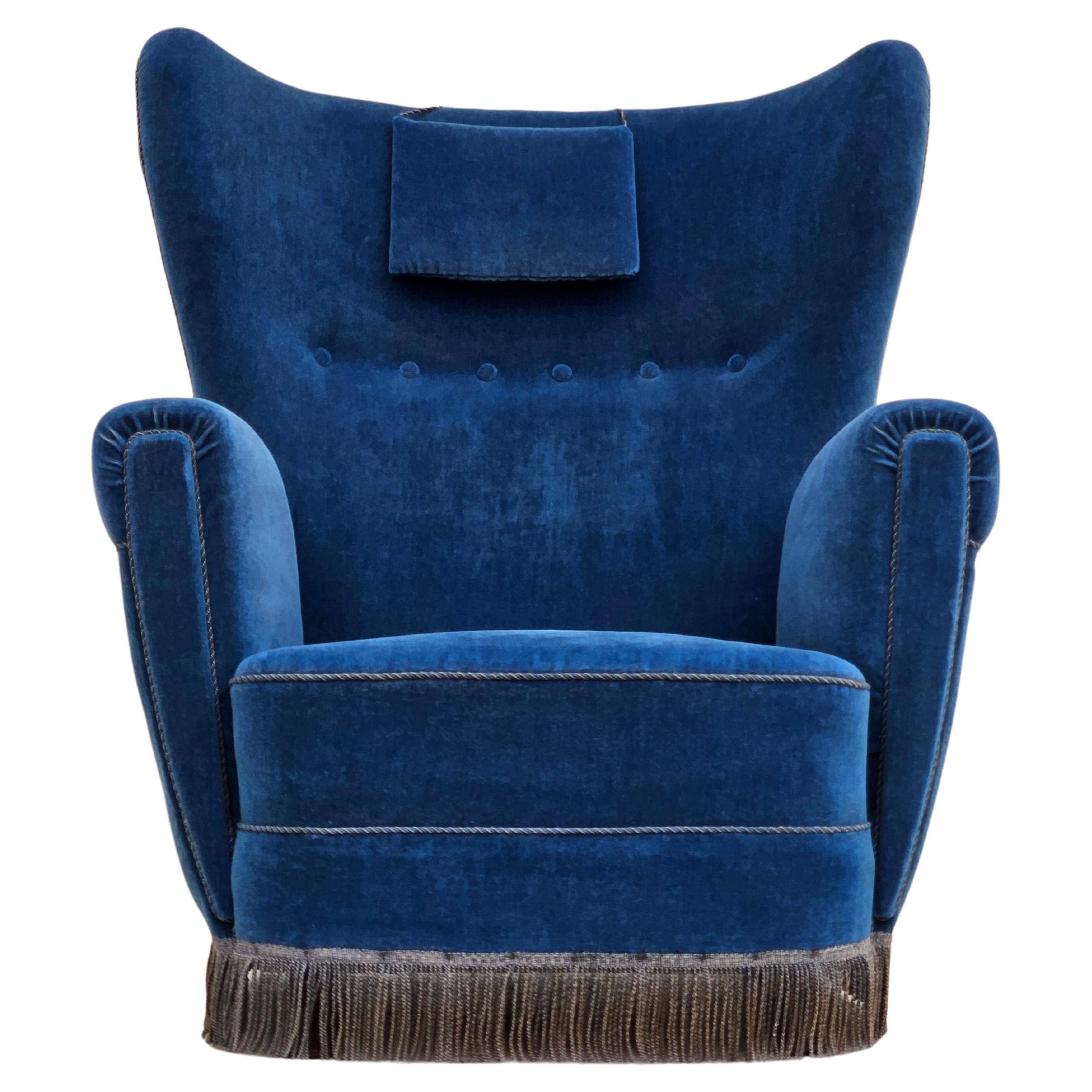 1960er Jahre, dänischer Sessel mit hoher Rückenlehne in sehr gutem Originalzustand: keine Gerüche und keine Flecken. Blauer Möbelvelours, Buchenholzbeine, Messingfedern im Sitz, Nackenkissen. Hergestellt von einem dänischen Möbelhersteller etwa in
