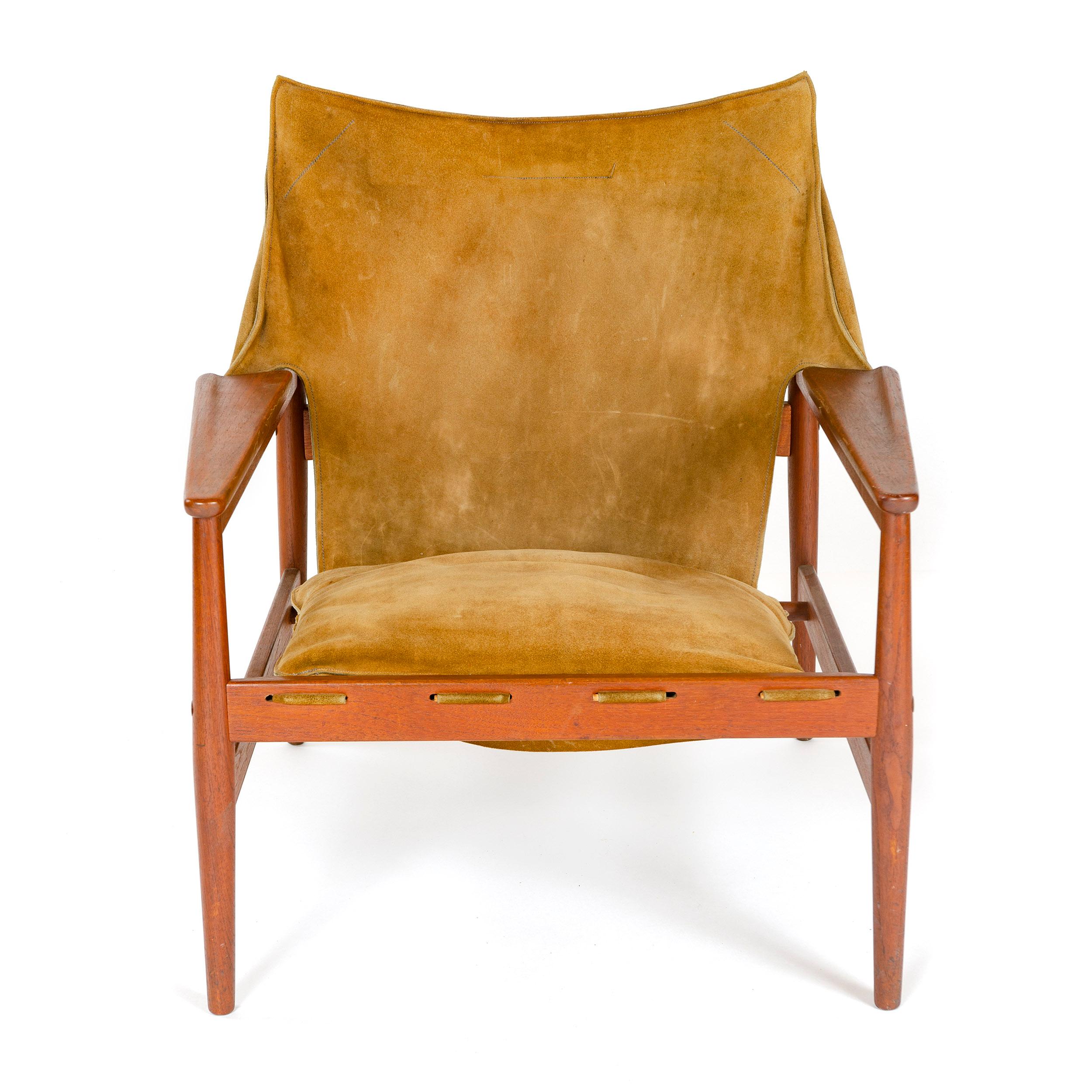 A lounge chair with leather upholstery on an exposed teak frame with buckle straps and a matching loose bottom cushion.