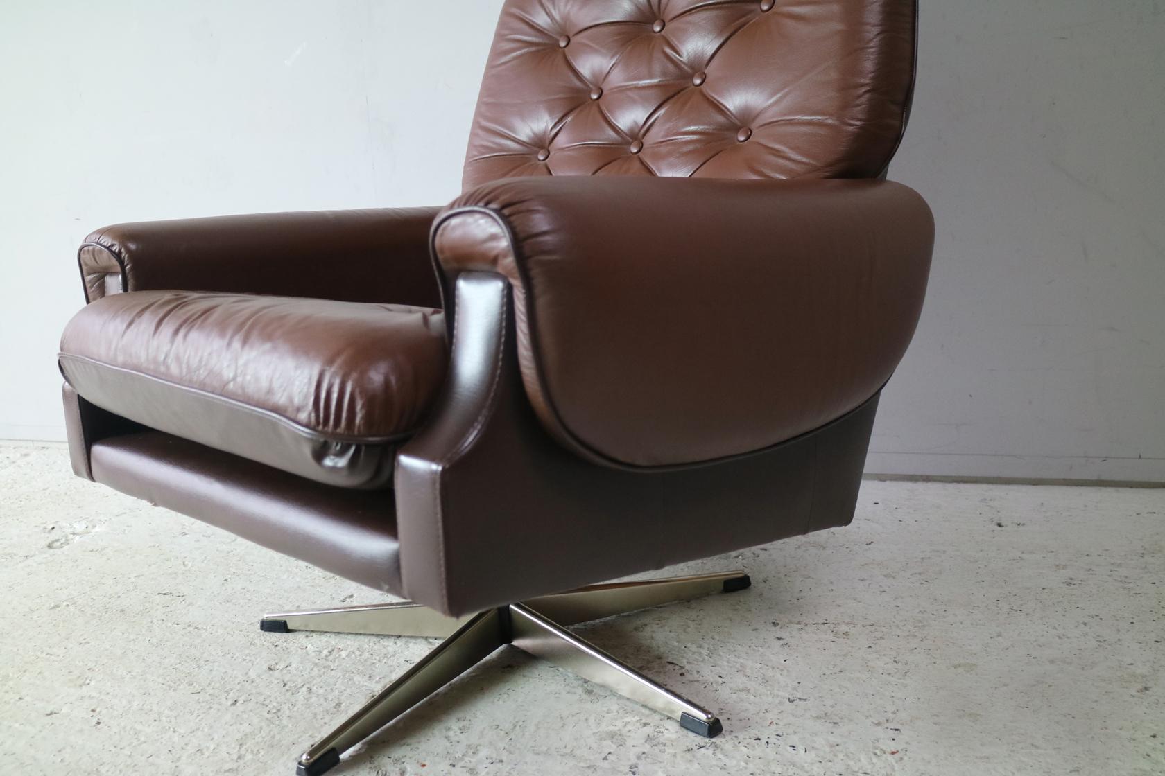 A very distinctive Danish brown leather swivel armchair / lounge chair. With the original leather upholstery consisting of two different brown shades, one for the upper seating and one for the lower part of the cushion and frame.

Lovely wrap over