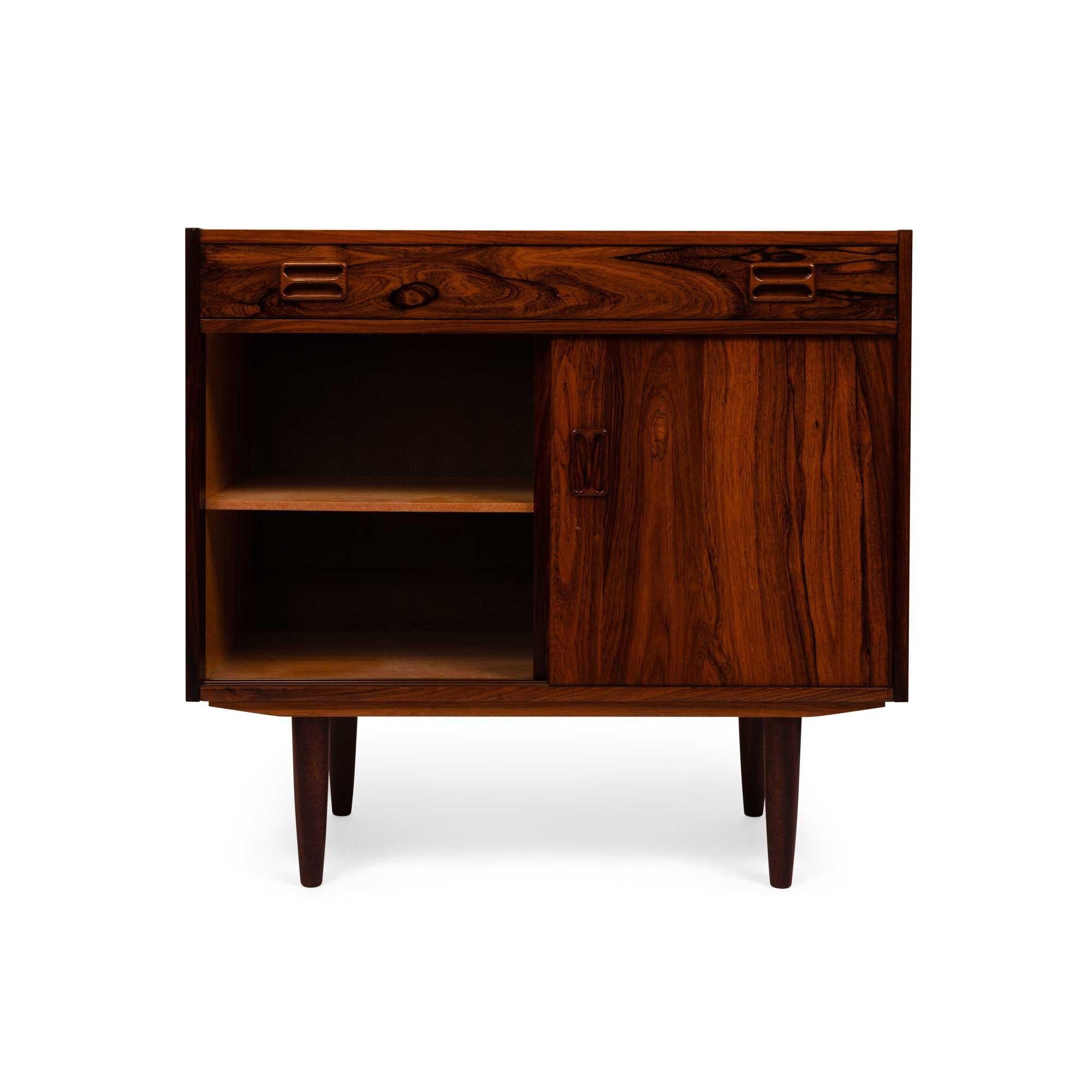 This stunning Danish Mid-Century credenza showcases the unparalleled beauty of richly grained rosewood, exuding timeless elegance. The captivating wood grain flows seamlessly across the surface, a testament to expert craftsmanship.

Designed with