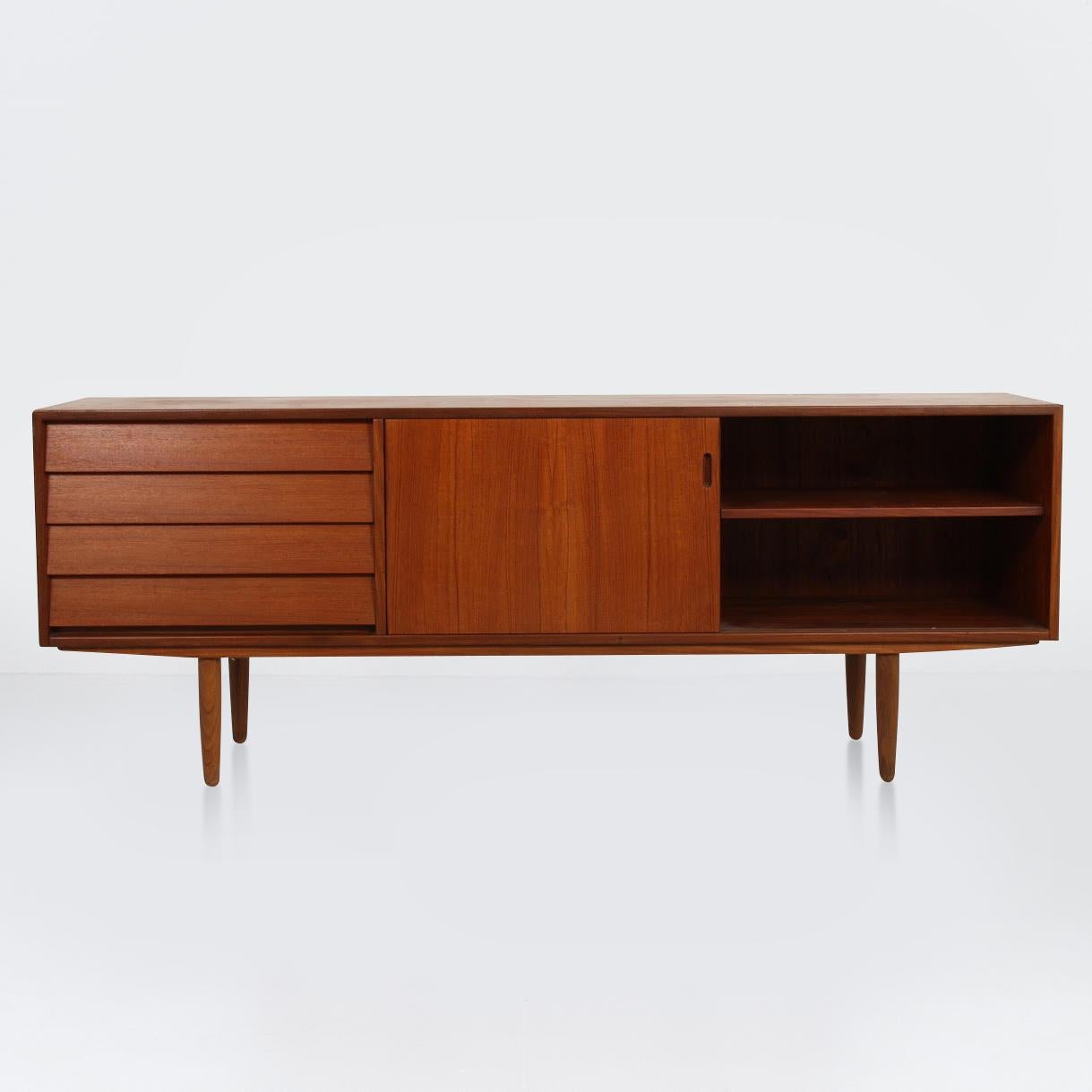 Low-line richly grained teak veneer sideboard

This cabinet has a uniquely designed bank of four drawers and sliding doors which open to reveal fixed shelved storage space

Designed and produced in Denmark in the 1960s
