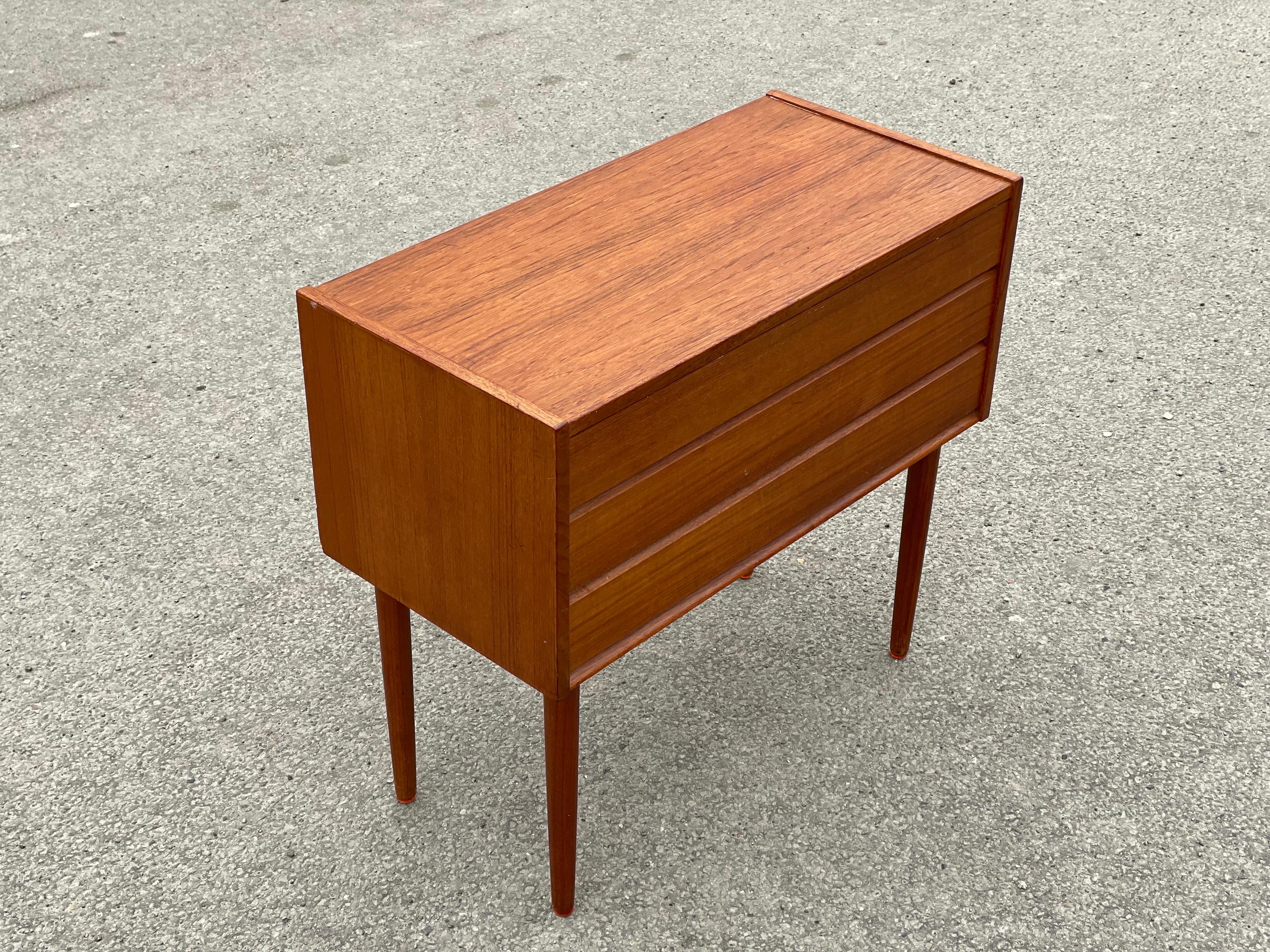 Danish teak dresser, 1960s small and elegant teak dresser with three wide drawers and round tapered legs.