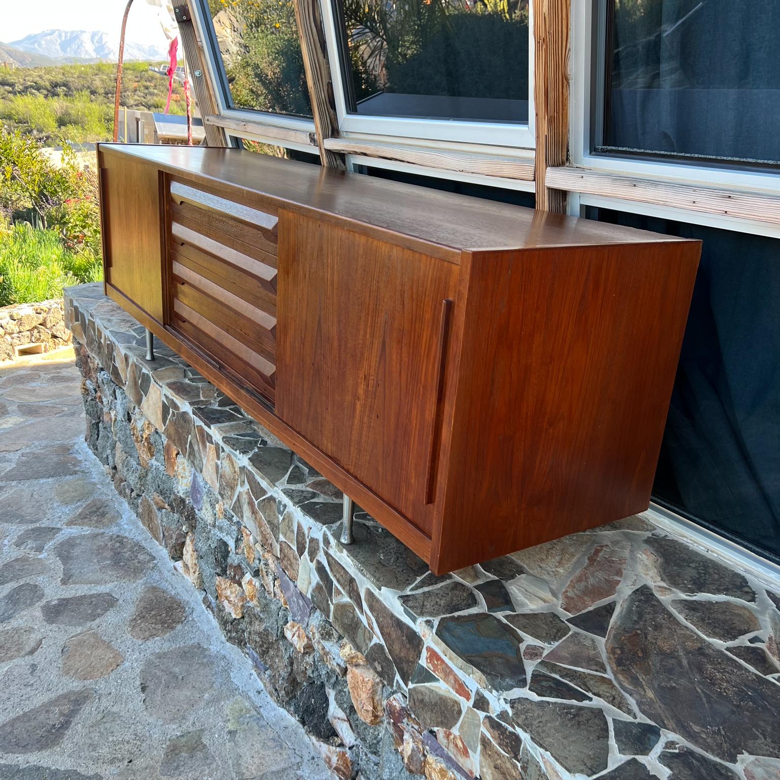 1960s Danish Mod Credenza Sideboard in Teakwood.
Stunning beauty.
In the Style of Johannes Andersen
Unmarked
Measures: 78.75 W x 20 D x 26.25 H.
Original preowned vintage condition.
Refer to images provided.
Delivery to LA OC Palm