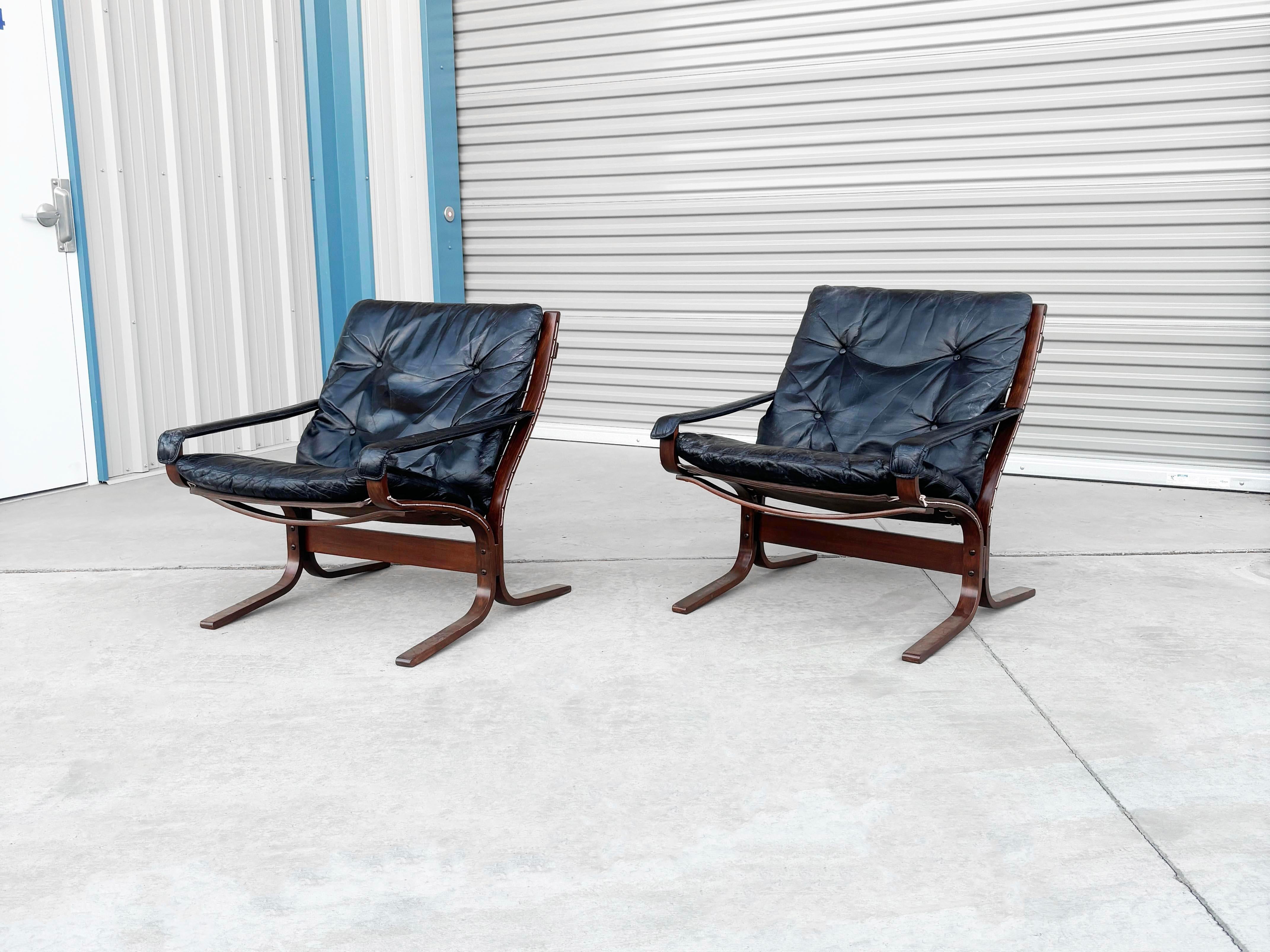 Pair of stunning siesta lounge chairs crafted by renowned designer Ingmar Relling and expertly manufactured by Westnofa in Norway during the 1960s. These iconic chairs showcase a vibrant black leather upholstery elegantly resting on a beautifully