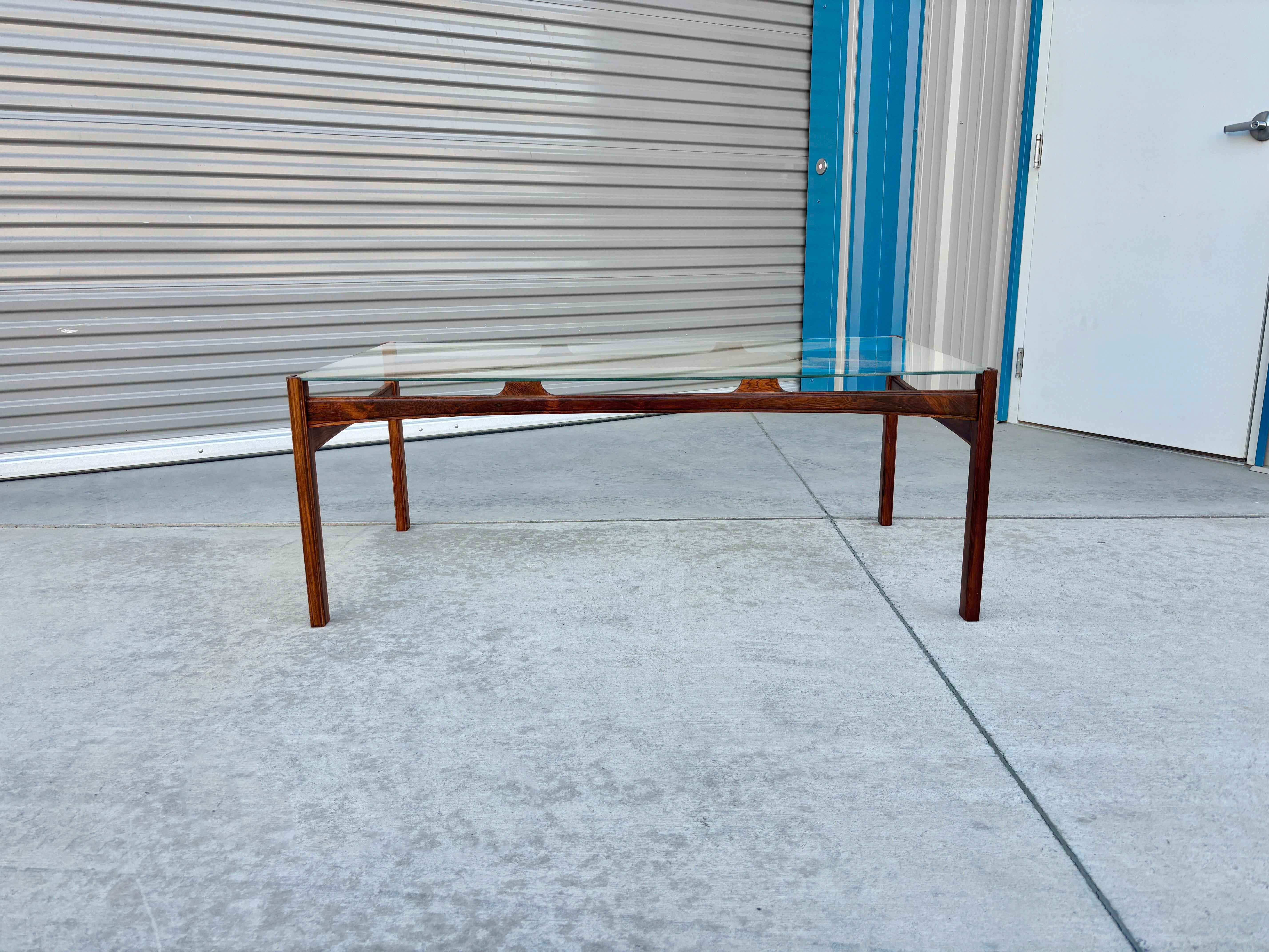 ✨ Danish Modern Rosewood & Glass Elegance ✨

This vintage Danish Modern coffee table is a striking blend of clean lines, rich materials, and timeless craftsmanship. The rectangular glass top rests securely on a newly refinished rosewood base,