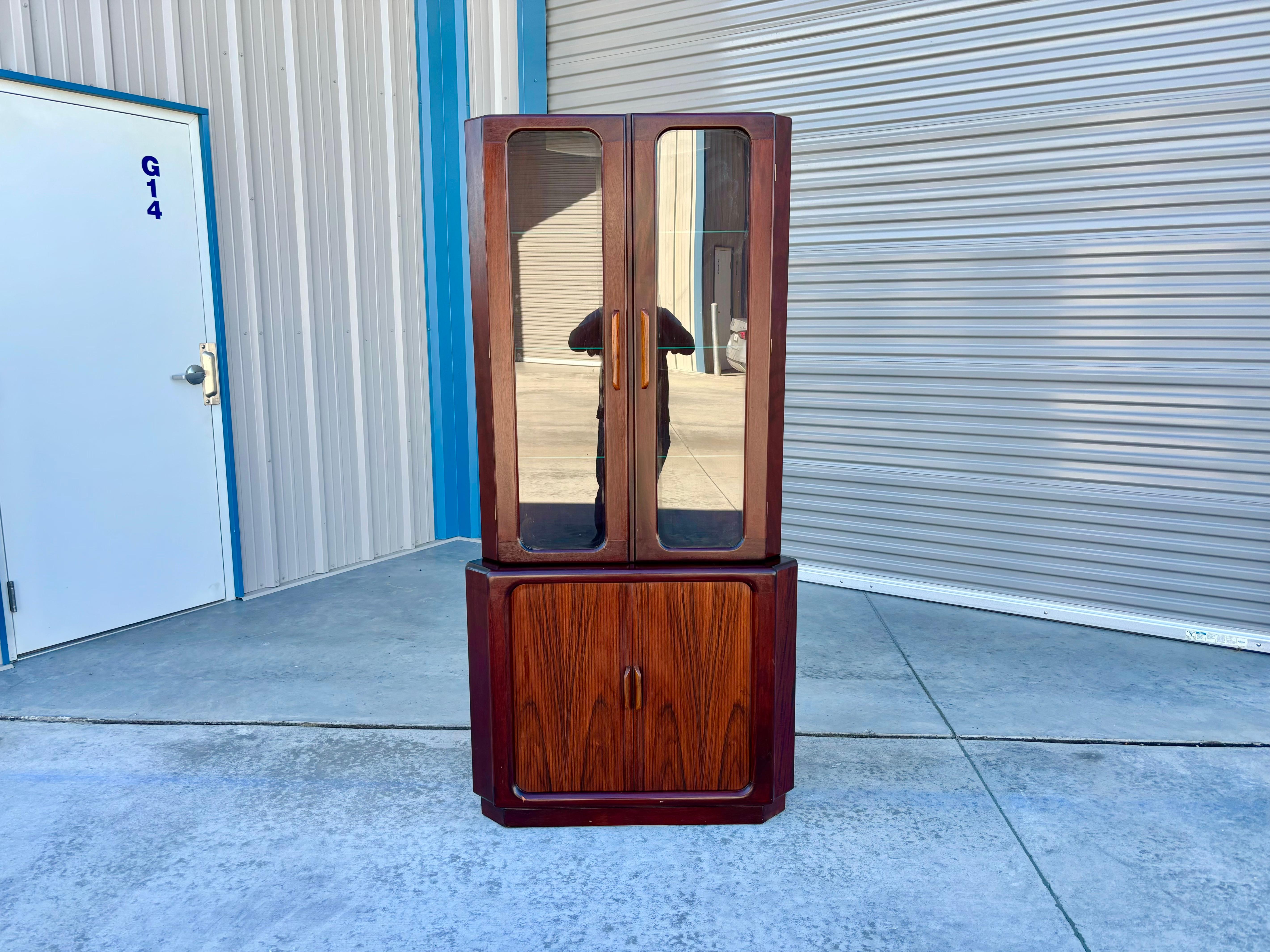 Danish modern rosewood corner cabinet designed and manufactured by Dyrlund in Denmark circa 1960s. This fabulous corner cabinet features a rosewood frame. What sets this corner cabinet apart from others is that it can be split into two parts, making