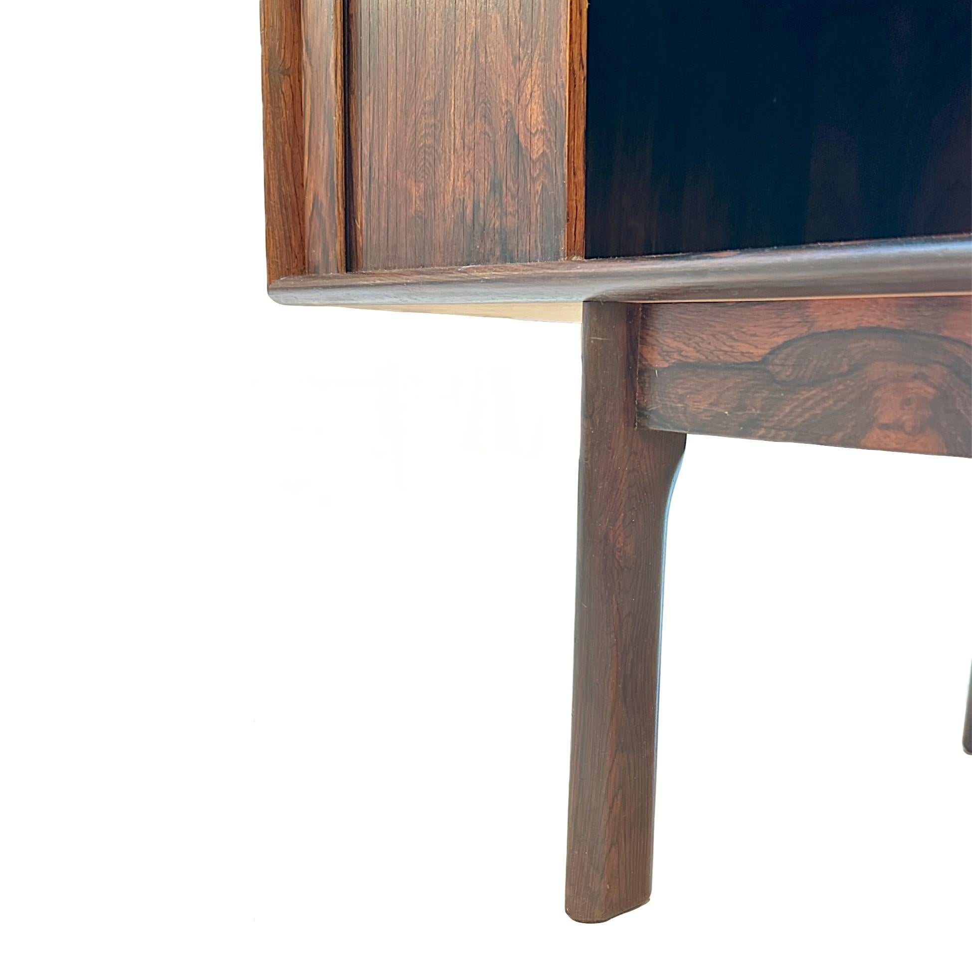 An exceptional example of 1960s Danish Modern design, this rosewood credenza by Henning Kjaernulf for Bruno Hansen features elegantly crafted tambour doors and a refined, minimalist silhouette. Showcasing the richness and natural variation of