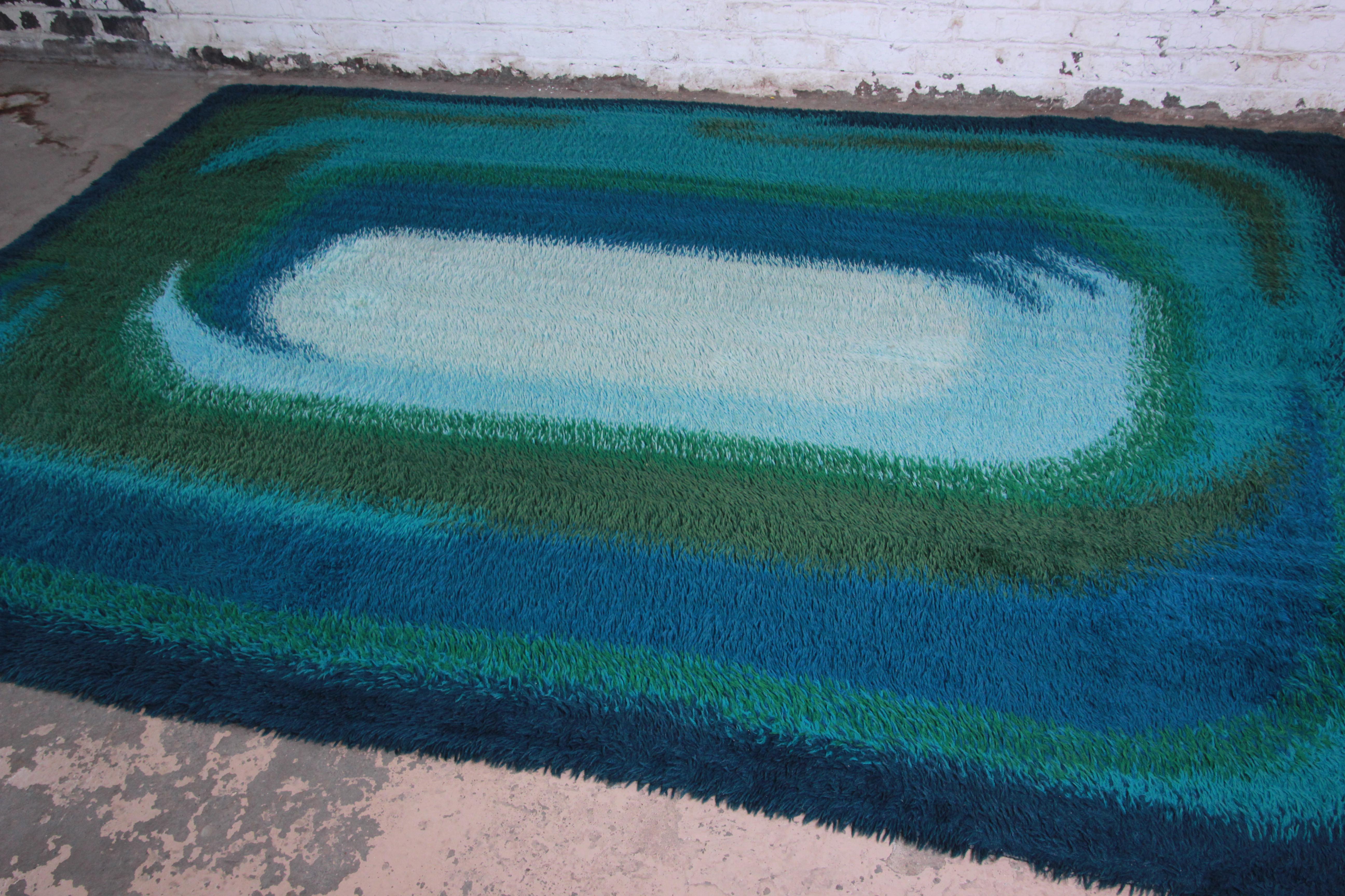Offering a stunning midcentury Danish modern rya shag rug. The rug has a unique abstract design in vivid colors of blue, teal, and green. It has a thick, soft wool pile throughout. A very nice and clean rug for any modern or Mid-Century Modern