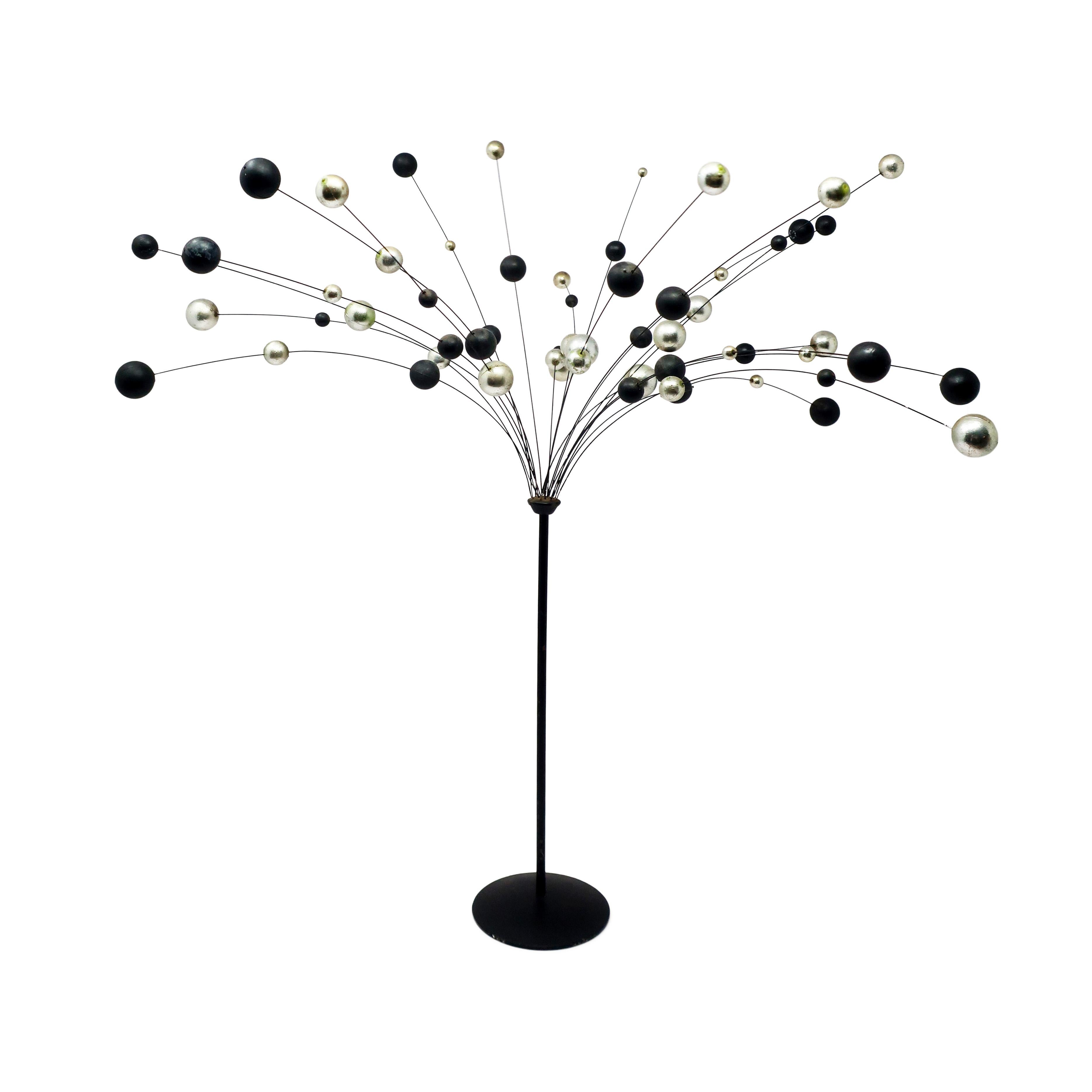 A vintage kinetic ball sculpture in the style of Laurids Lonborg, a Danish housewares and decorative objects powerhouse. Black metal base and stem, silver metal wires, and silver and black colored balls that gently sway with any movement, giving it