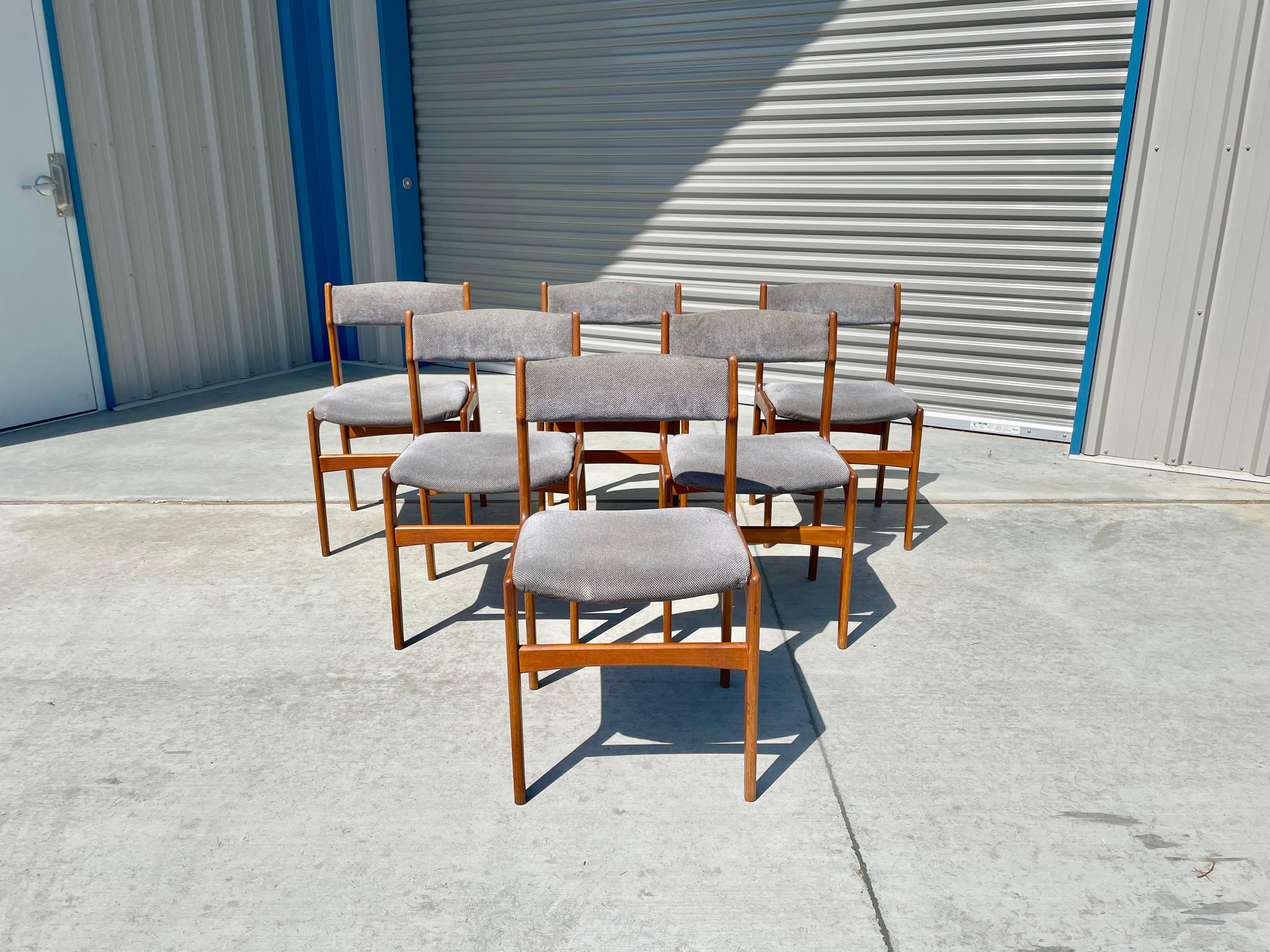 Danish modern teak dining chairs were designed and manufactured in Denmark circa 1960s. These stunning dining chairs feature a strong teak frame creating a refined and elegant look. The chairs also feature a gray upholstery, perfect for your next