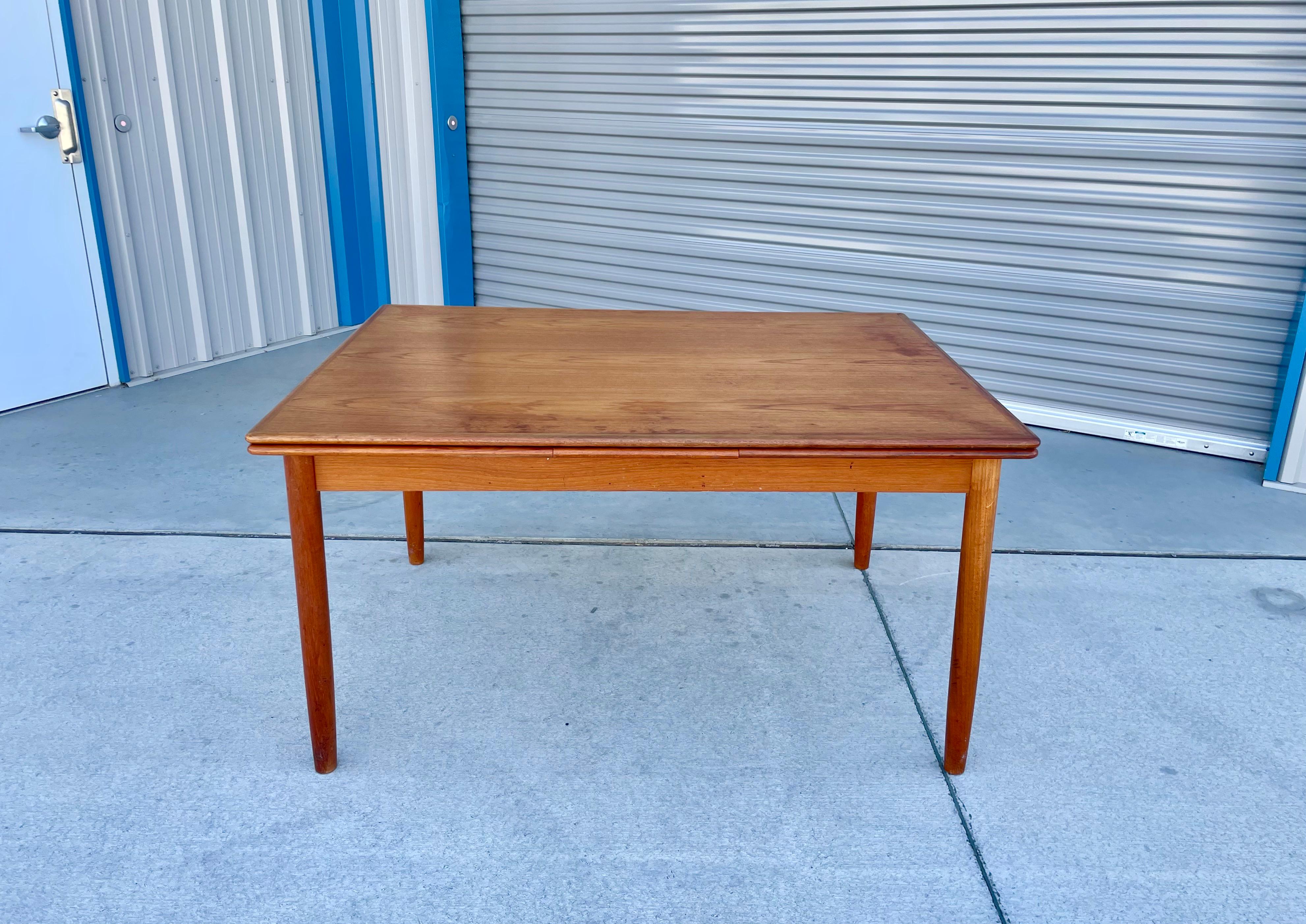 Danish Modern teak extending dining table designed and manufactured in Denmark 1960s. This beautiful dining table was made with the highest quality of teak. One of the best features of this table is that it comes with two pull-out leaves. All you