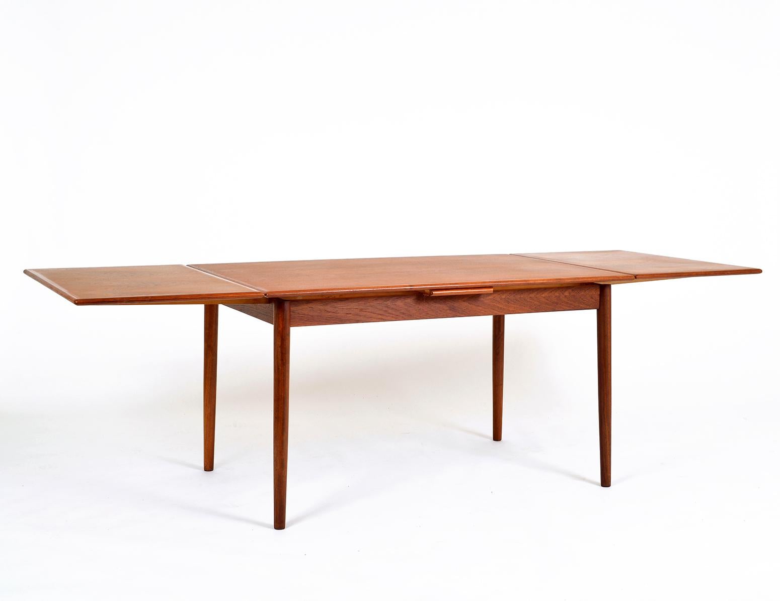 Slim, sleek and very stylish, this 1960s Danish modern draw leaf teak extending dining table was manufactured by AM Møbler (Ansager Møbler) Denmark. It seats six when closed (130 cm) and up to ten when extended (238 cm).
There are no marks or
