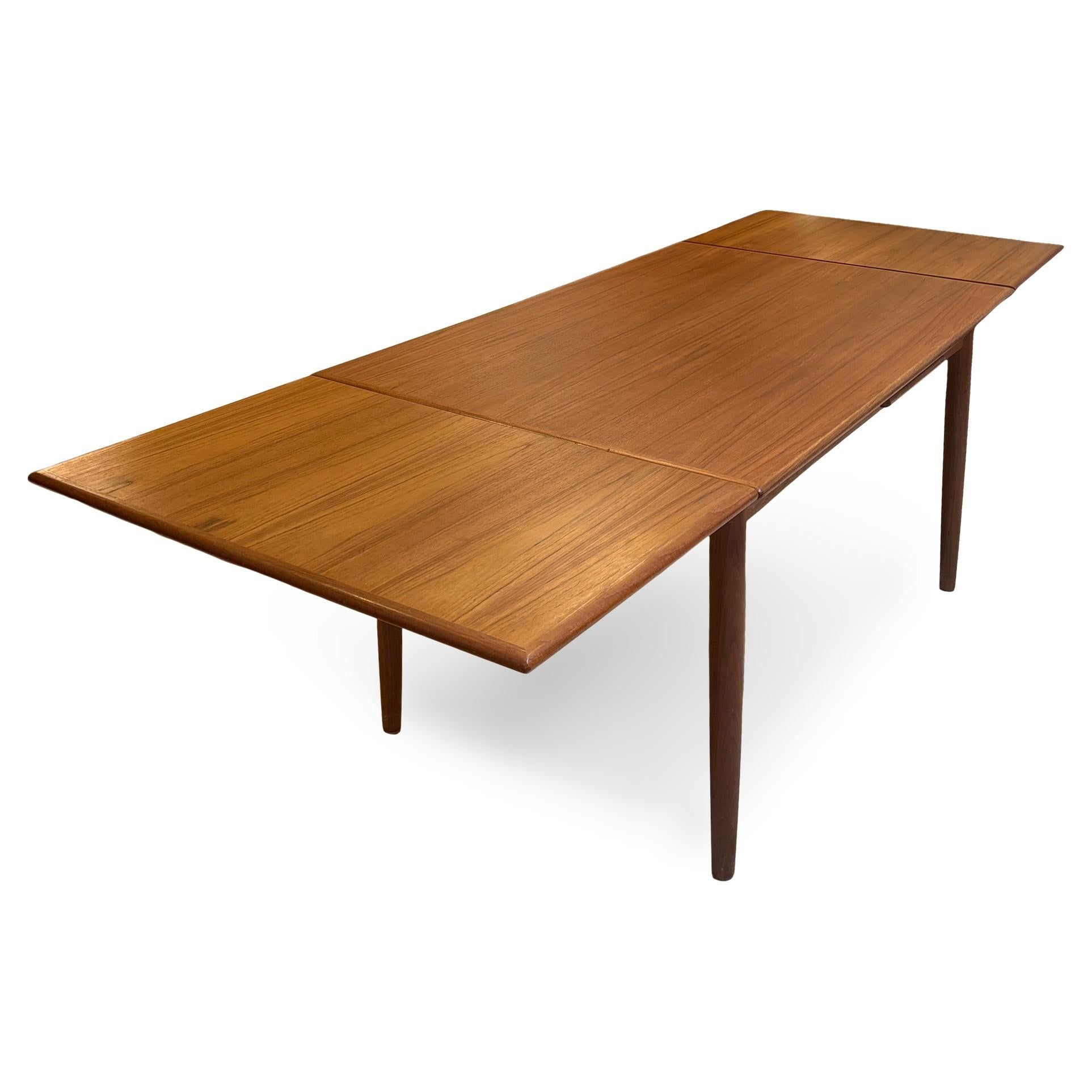 1960s Danish Modern teak dining table by N&R Møbler. The table has two leaves store underneath the top and pull out from either end to extend the dining surface. The table measures 51.5” long, with each leaf adding 19.75” for a total width at