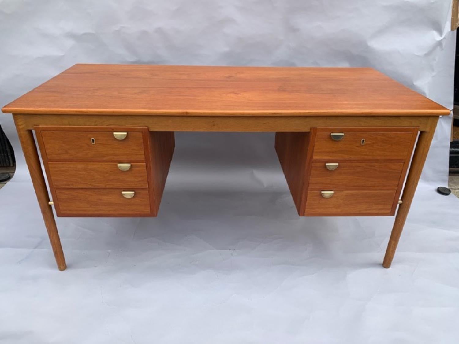 A stunning 1960s Danish oak and teak writing desk in the style of Børge Mogensen for Søborg Møbelfabrik. The two sets of suspended drawers which are cut into the desktop are held in place by four brass horizontal rods which are connected to each