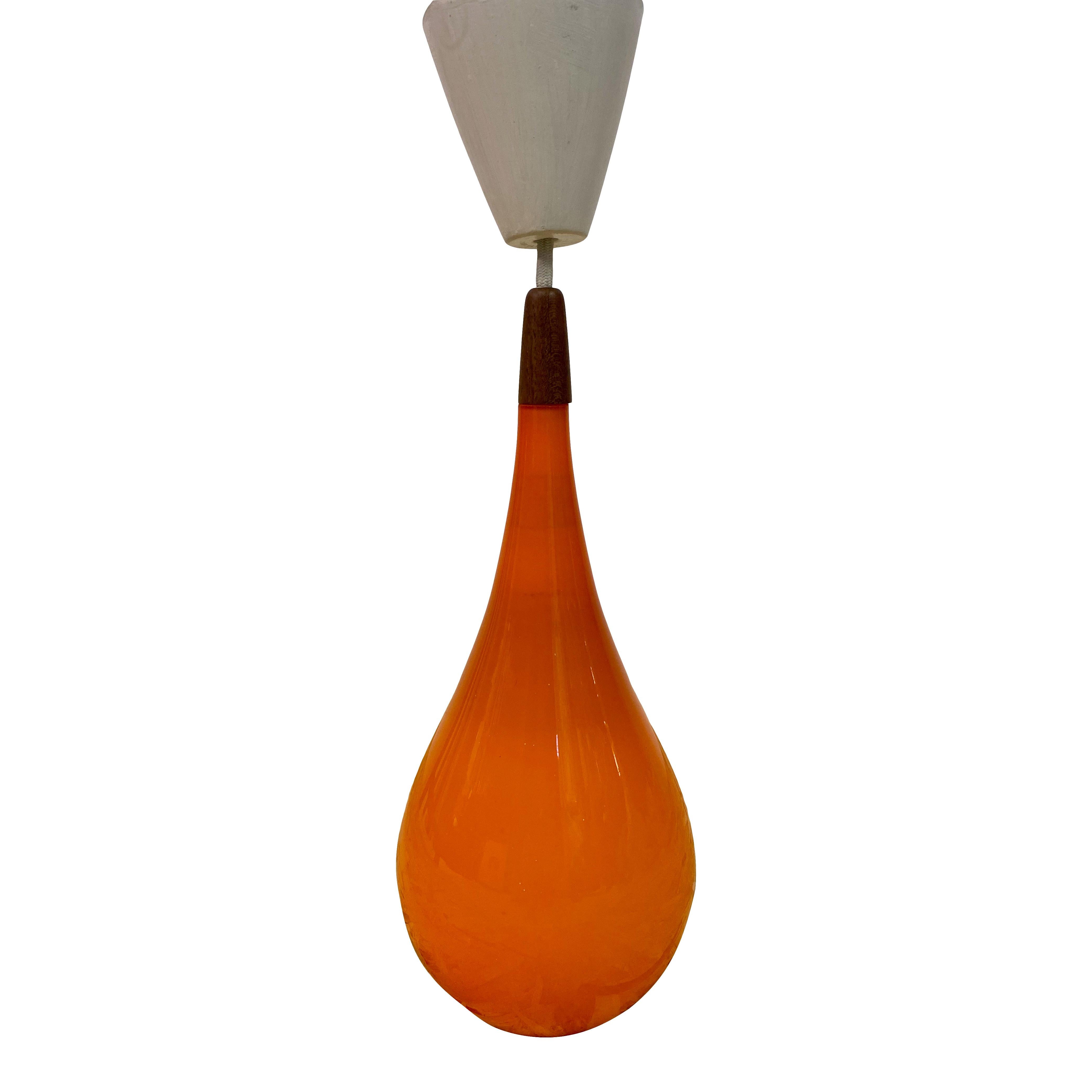 Orange glass pendant

By Holmegaard

Stamped made in Denmark on inner cork stopper

Teak top

Denmark 1960s.