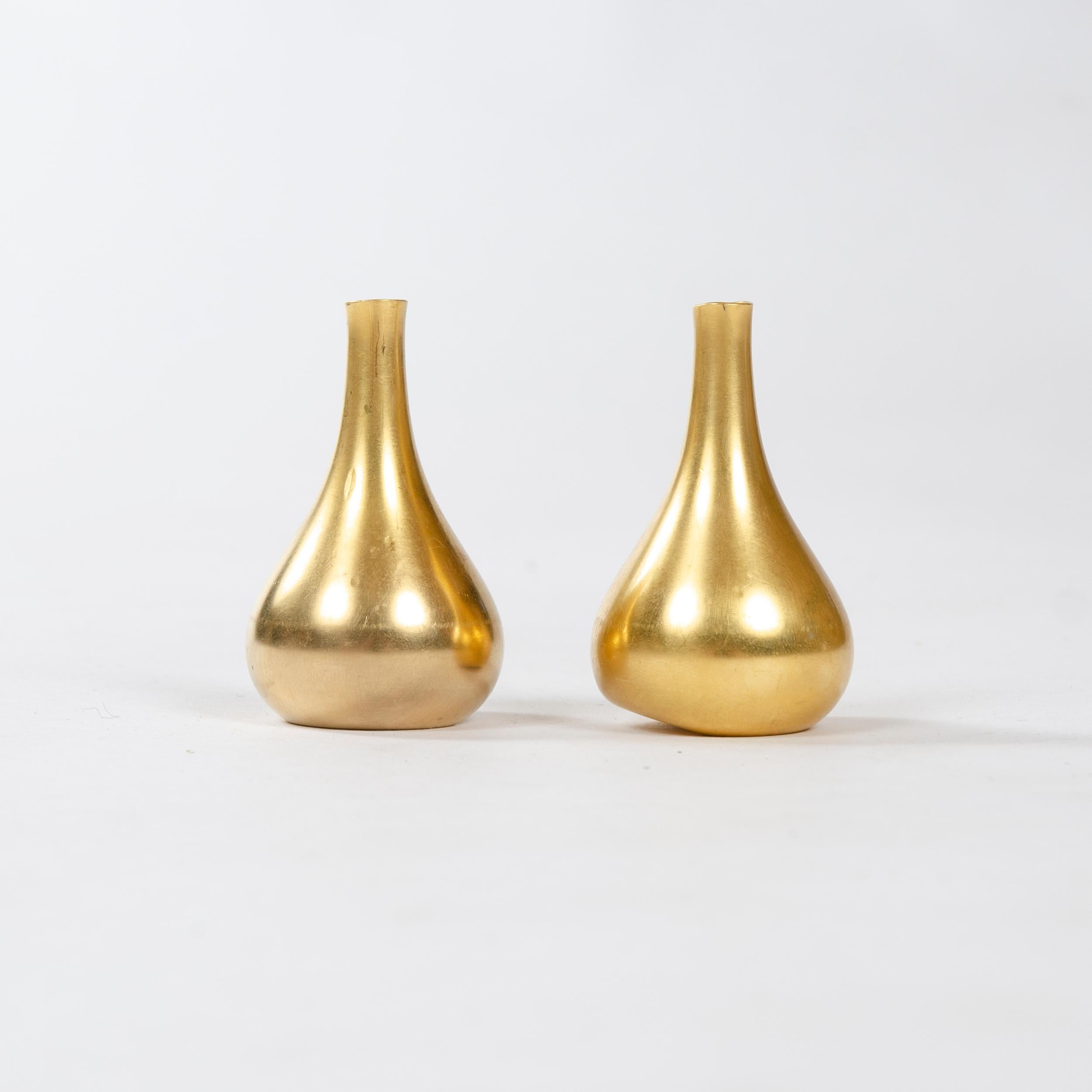 A pair of petite cast bronze candleholders with weighted and chamfered bottoms. Each stamped 