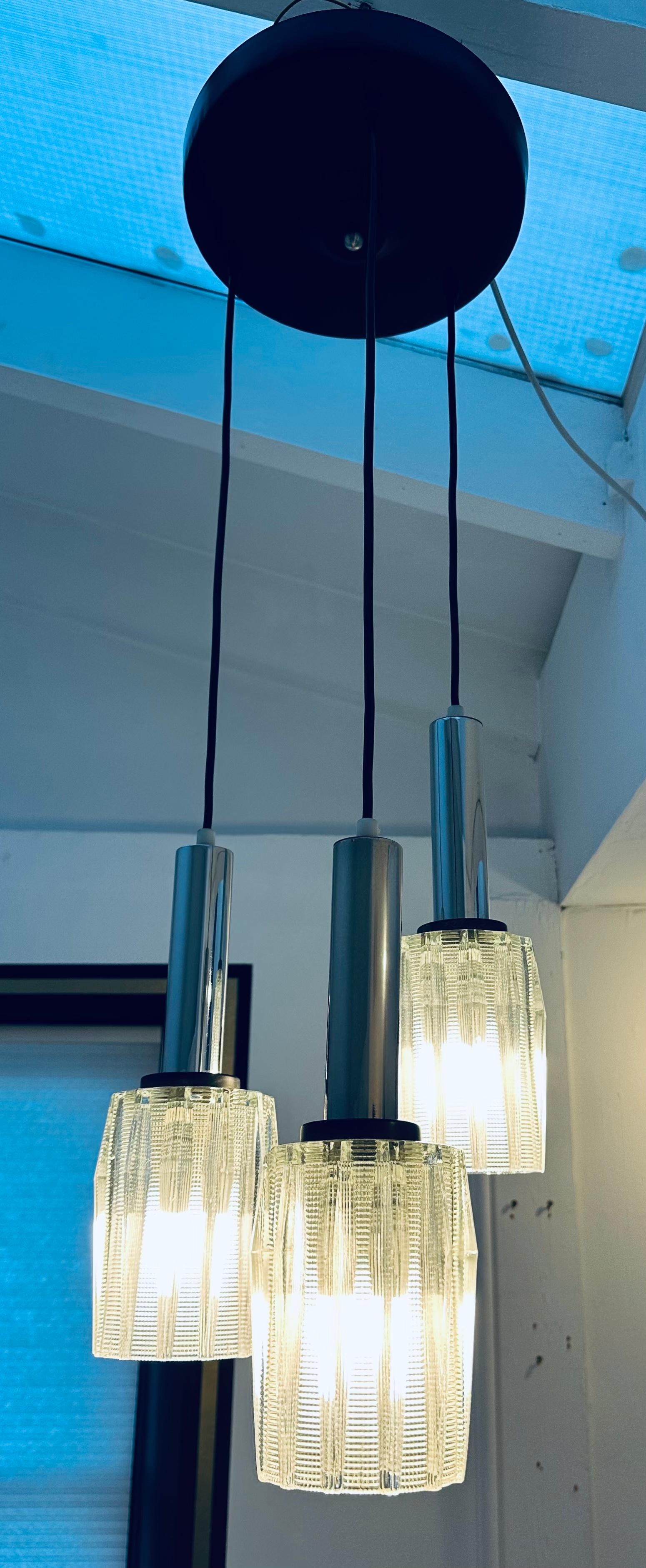 1960s Danish mid century triple glass shade hanging ceiling light.  The glass shades diffuse the light beautifully through the serrated glass design which is overlaid and interspersed with clear glass vertical fins.  The glass shades are suspended