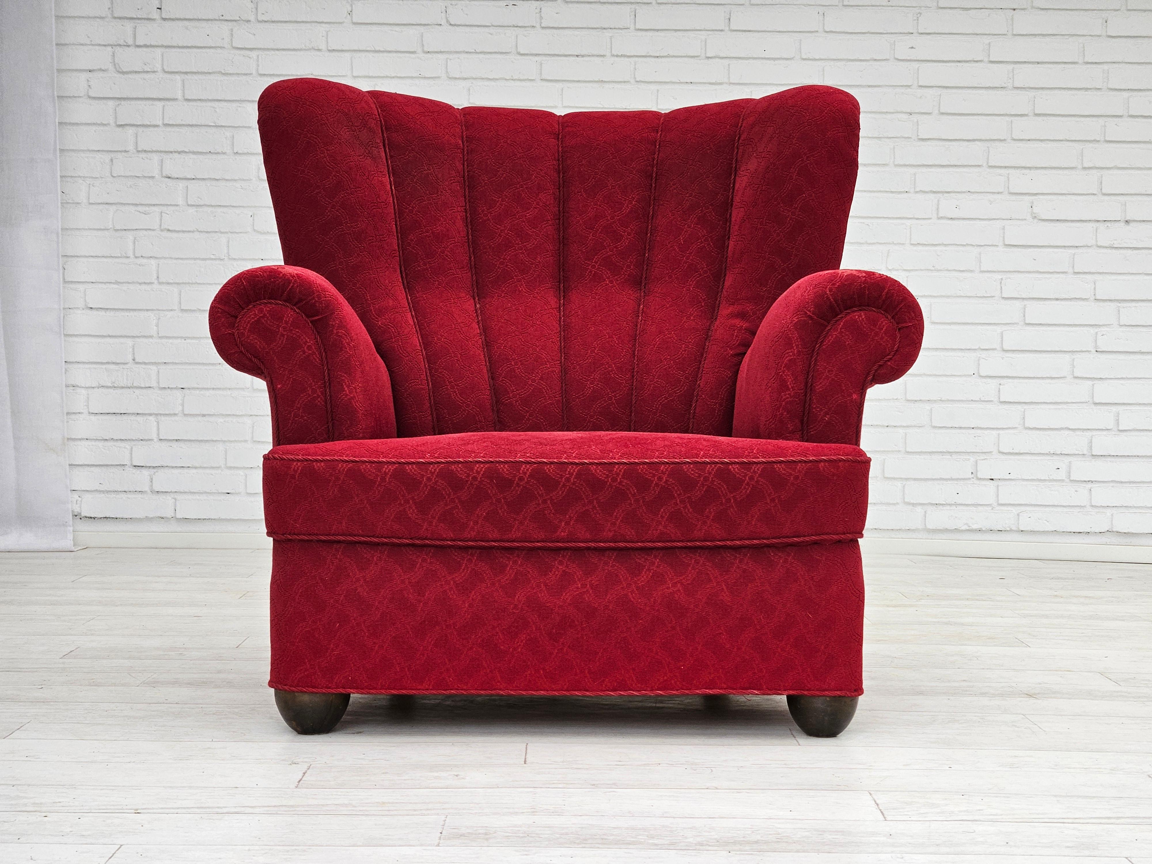 1960er Jahre, dänischer Relaxsessel in gutem Originalzustand: keine Gerüche und keine Flecken. Originaler roter Baumwoll-/Woll-Möbelstoff, Eichenholzbeine, Messingfedern in der Sitzfläche. Die Stoffoberfläche an der vorderen Armlehne ist leicht