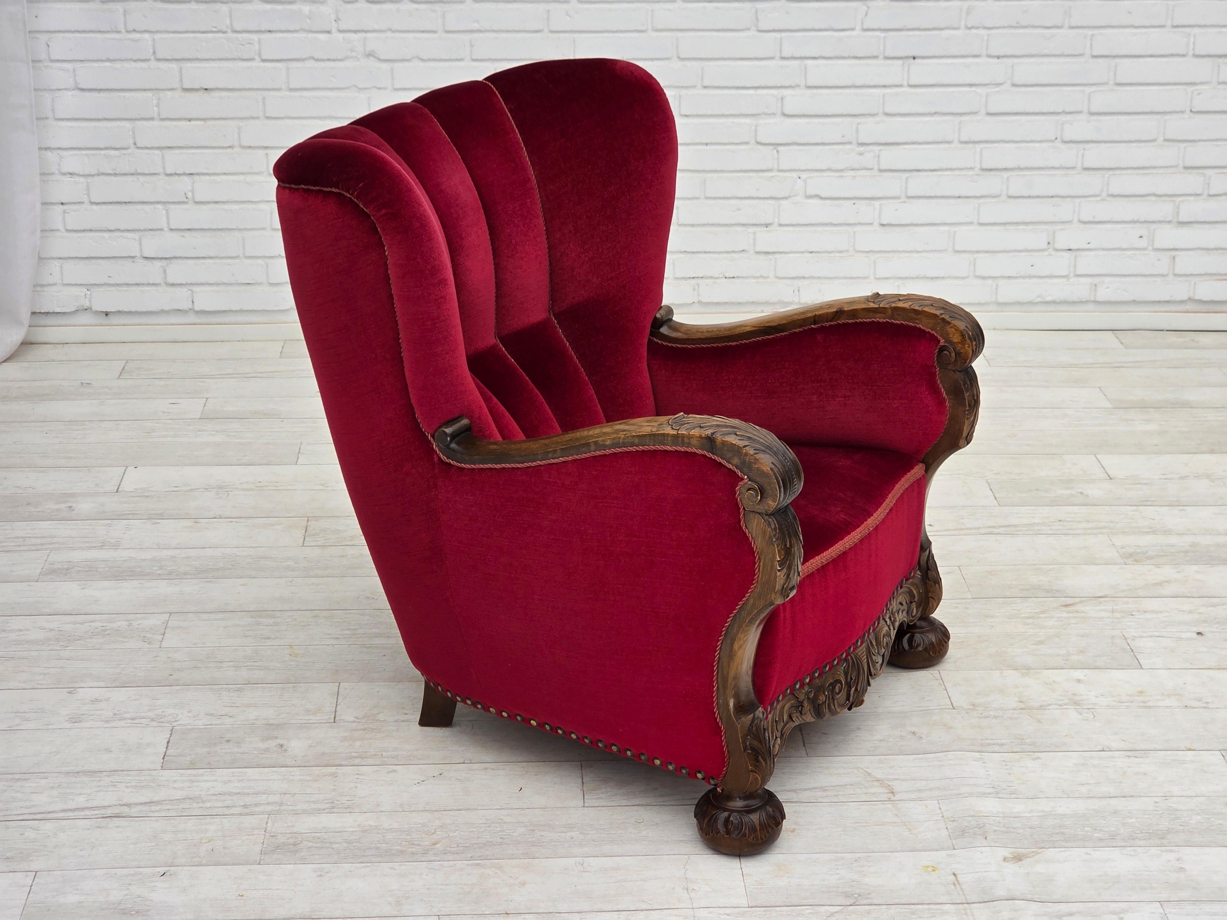 Divano danese a 2 posti degli anni '60. Velluto rosso da arredamento, gambe in legno di frassino, molle in ottone nella seduta. Il divano è stato tappezzato da un artigiano circa 15 anni fa. Buone condizioni: nessun odore, nessuna macchia e