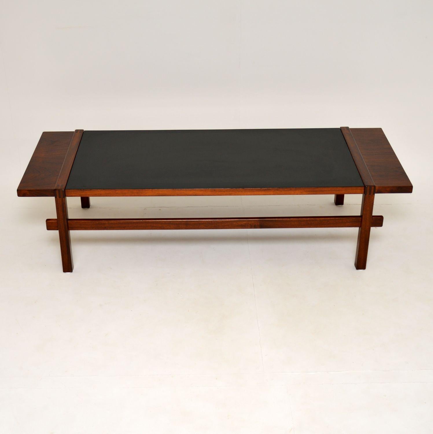 A stunning, very large and very unusual Danish coffee table. This dates from the 1960s.

It has a unique reversible mechanism that we have never seen before. The centre of the top is wood on one side and black formica on the underside. There is a