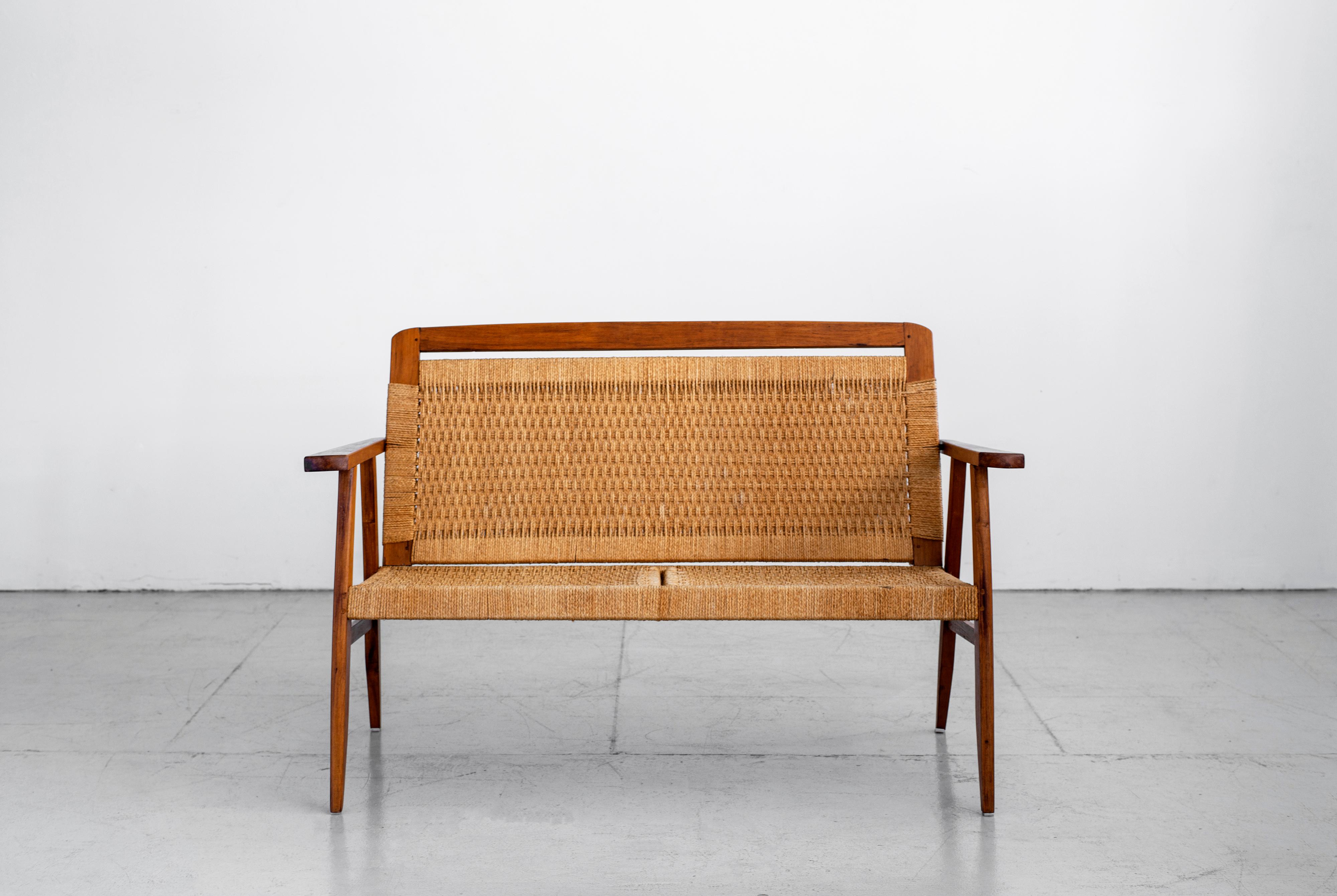 Beautiful vintage Danish bench with angled teak legs and tightly woven rope seat. Back of seat tilts to provide a perfect angle of comfort. Great age and coloring throughout.
