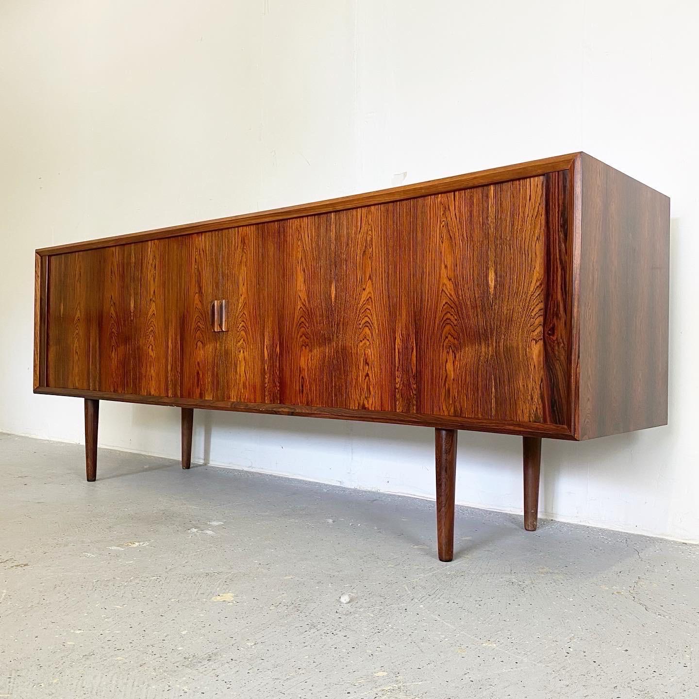 With striking rosewood grain throughout and plenty of concealed storage this credenza is a show stopper. The tambour doors work great and slide smoothly. This piece has not been restored but is in excellent vintage condition. A classic Danish modern
