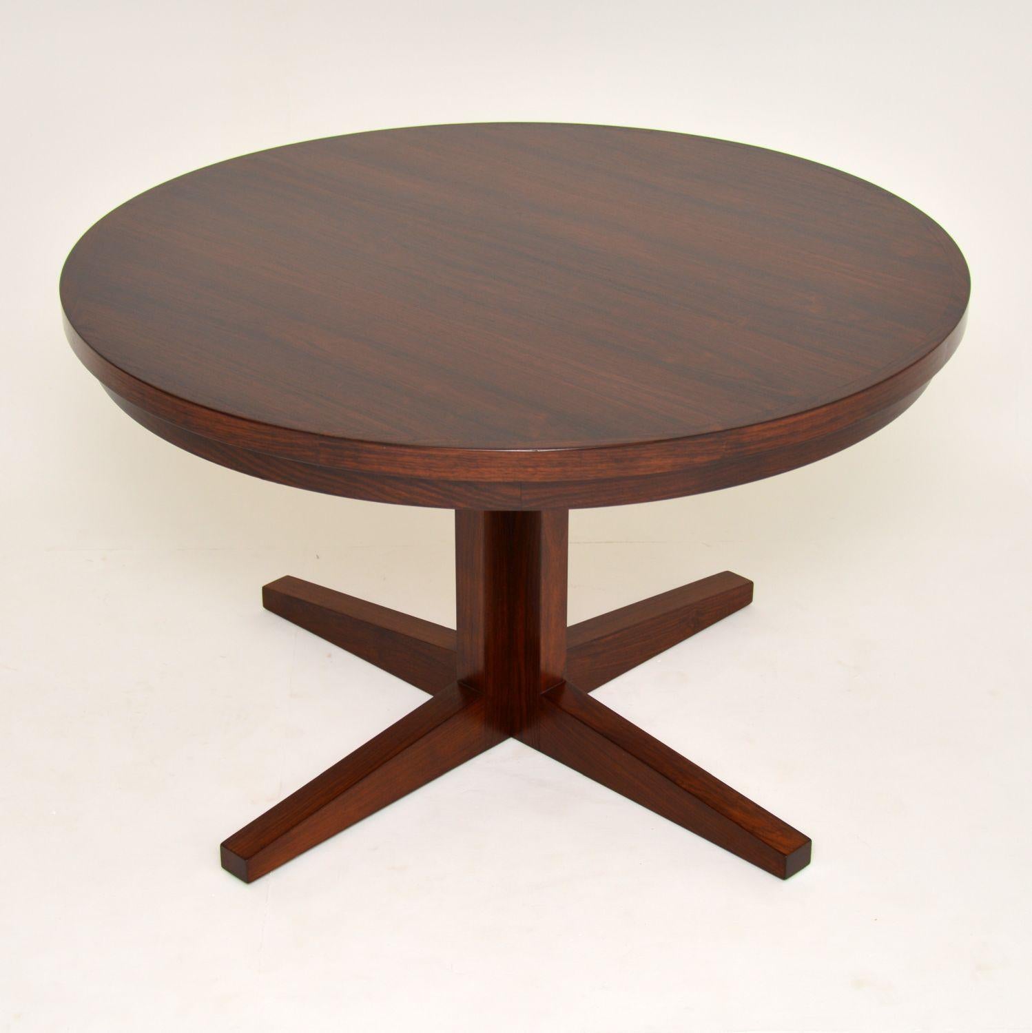 A stunning Danish dining table by Dyrlund, this is the famous flip flap lotus table, it dates from the 1960s. This is a very rare version, with a single column pedestal and a slightly smaller top and leaves than normal. The quality is absolutely