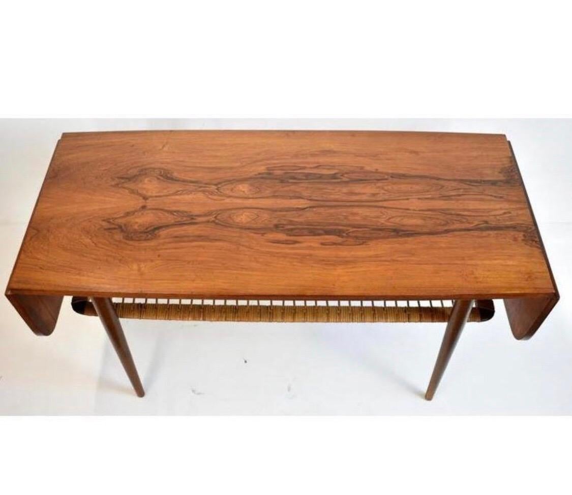 Mid-Century Modern coffee table features woven rattan lower shelf and 8