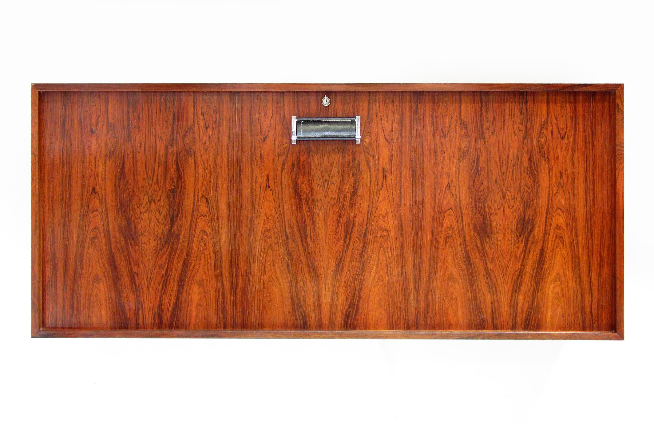 Closed dimensions - height: 55cm, depth: 39cm, width: 127cm
Open dimensions - height: 78cm, depth: 70cm, width: 127cm

A beautifully figured 1960s Danish rosewood wall-mounted bar or desk by Erik Buch for Dyrlund.

Of large dimensions, this