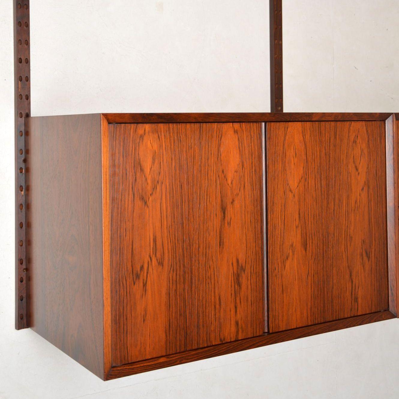 A superb vintage Danish wall unit. This is the Royal shelving system designed by Poul Cadovius, this was made by Cado in the 1960s. The quality is amazing, the vertical rails must be screwed to a wall, then the cabinets and shelves can be hung and