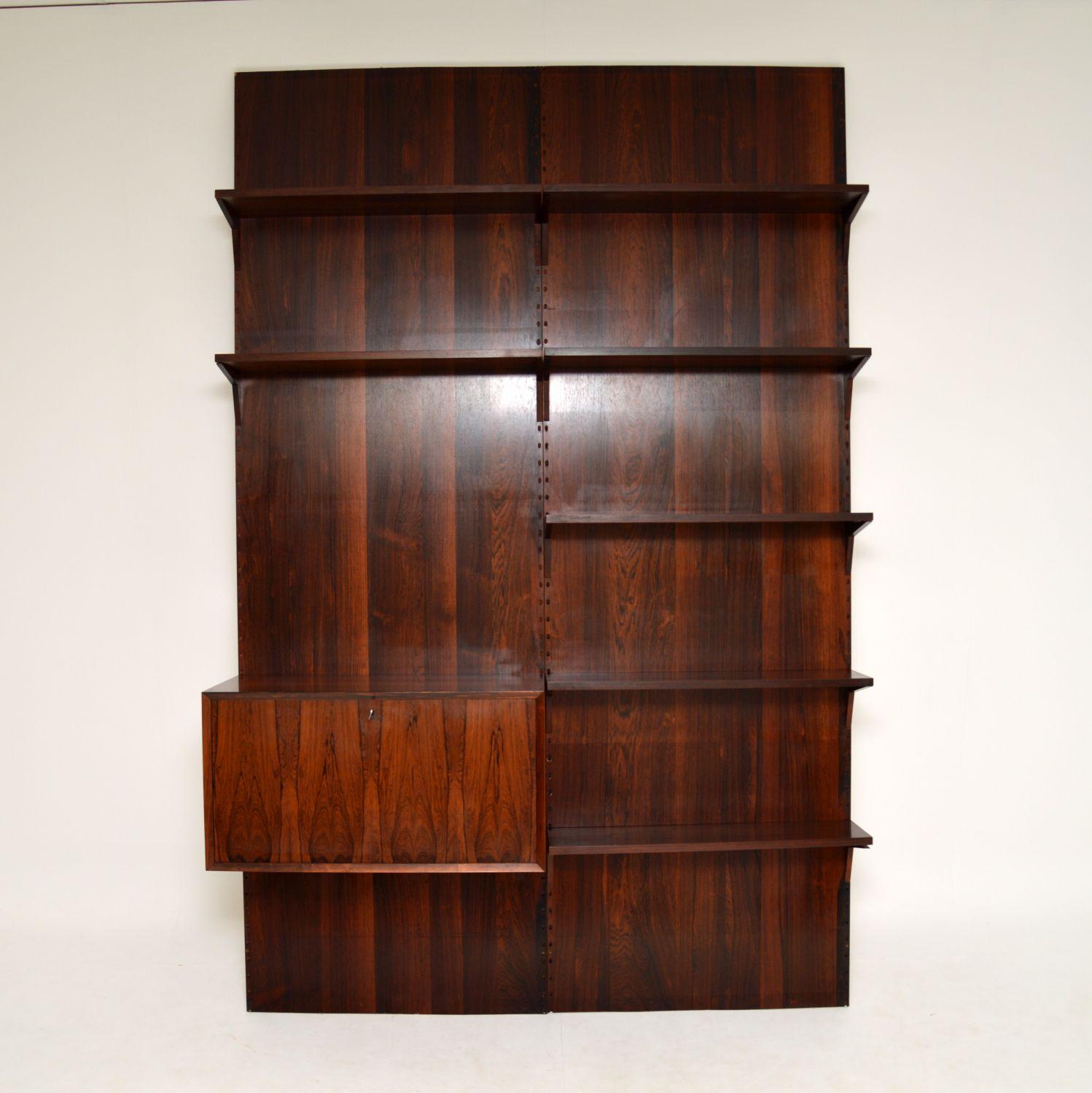 A stunning and rare vintage wood Royal Shelving system, designed by Poul Cadovius. This was made in Denmark, it dates from the 1960-70’s.

It is of absolutely superb quality, and is such a clever design. There are two large flat wood panels that