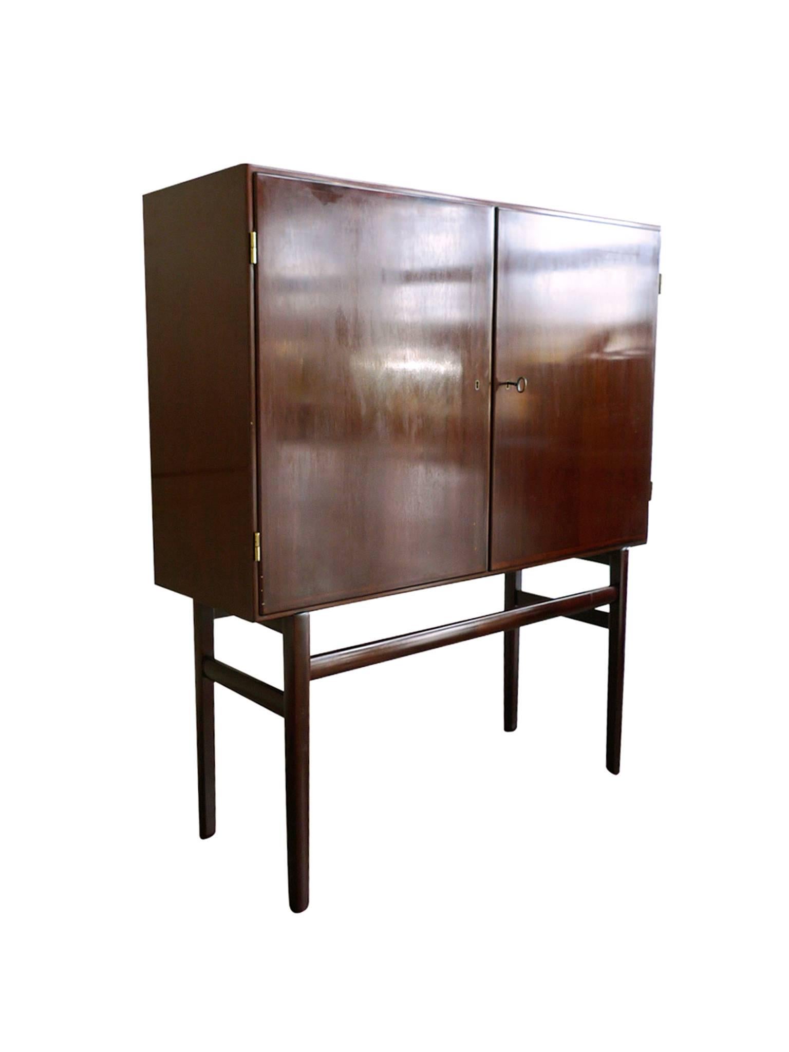 This Danish mahogany highboard or high sideboard, was designed in the 1960s by Ole Wanscher for the manufacturer Poul Jeppesen. Like many of Wanscher's designs, this sideboard combines warm-toned wood, soft, rounded edges, and Minimalist lines.