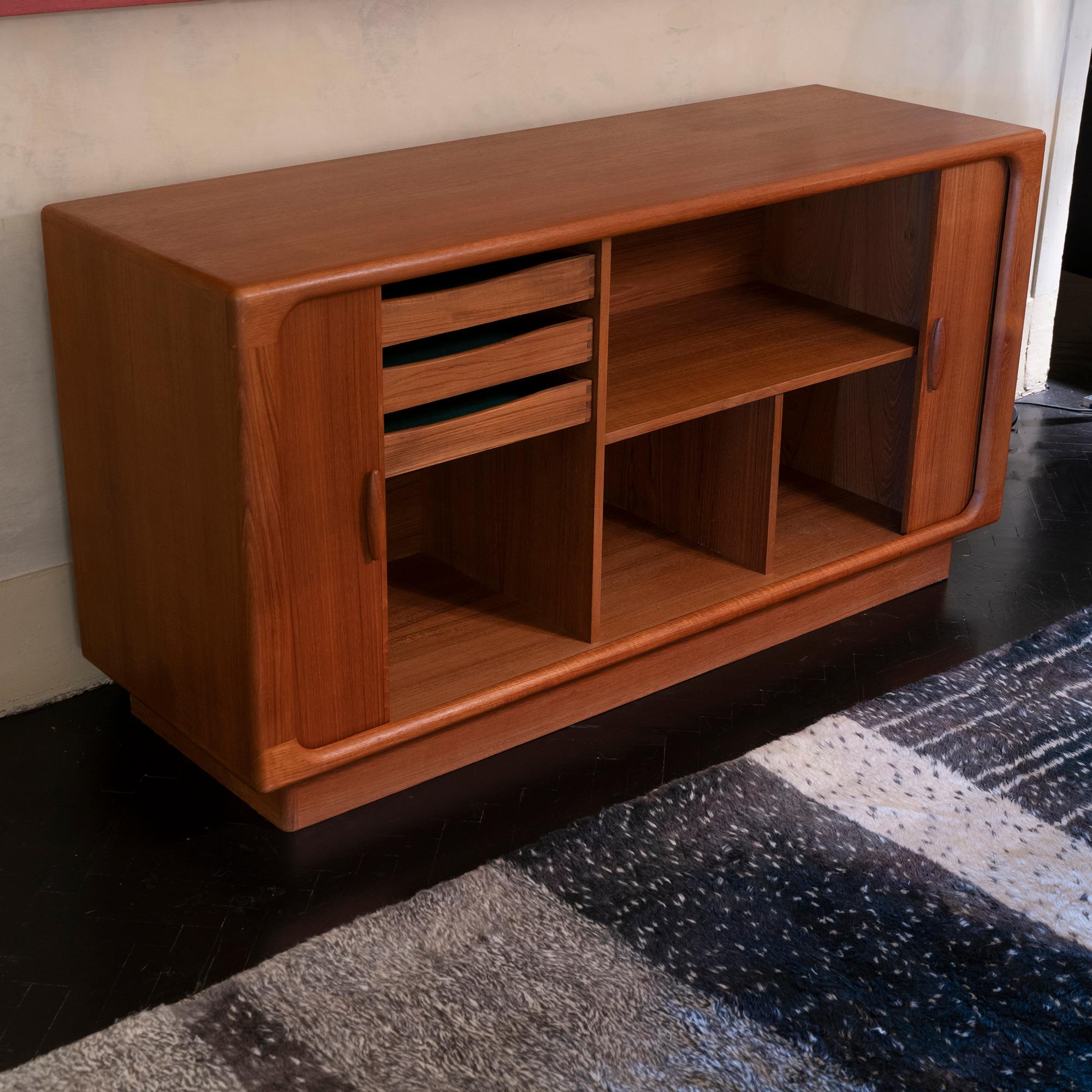 Danish design credenza or sideboard designed and produced by Dyrlund furniture makers in the 1960s, the organic shaped wood structure, two tambour doors that disappear completely when opened.
The interior has 3 drawers and fixed shelves, slight