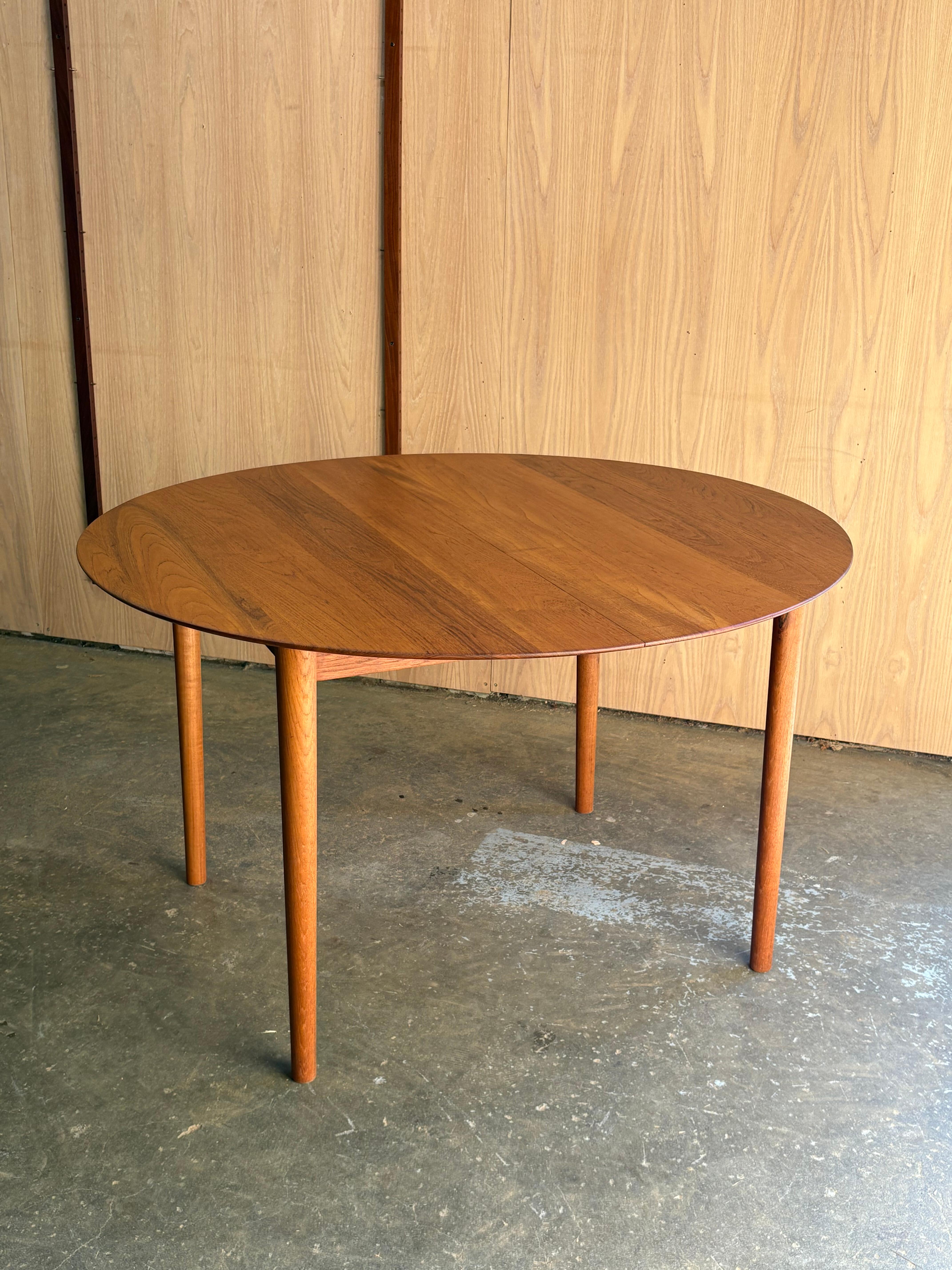 A remarkable 1960s solid teak dining table by Peter Hvidt for Soborg Møbelfabrik, crafted from exquisite old-growth teak that radiates warmth and depth. The slightly elliptical surface is finished with a refined bladed edge, showcasing both elegance