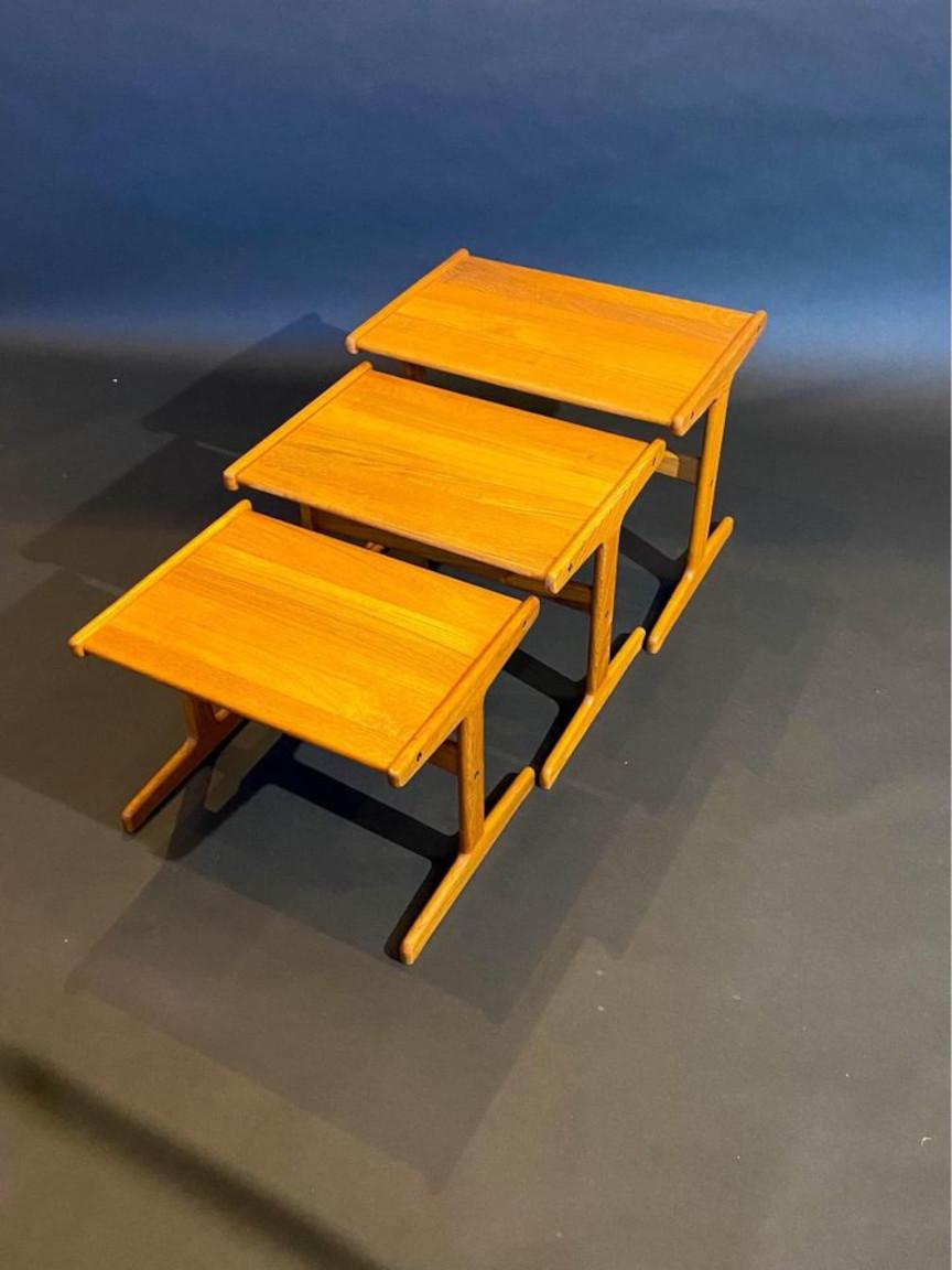 A timeless set of three solid teak nesting tables originating from the 1960s. These tables elegantly tuck into one another, offering a space-saving solution, while also functioning independently as versatile side, end, or occasional tables. Each
