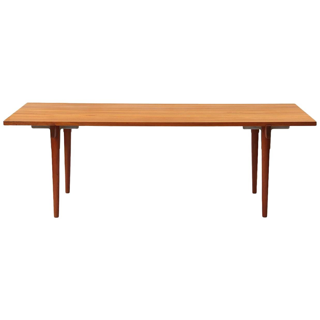 A rare Danish modern solid teak table / desk with clean sides and a recessed apron with chromium hardware. Designed by Hans Wegner, crafted by Johannes Hansen in the 1960s.