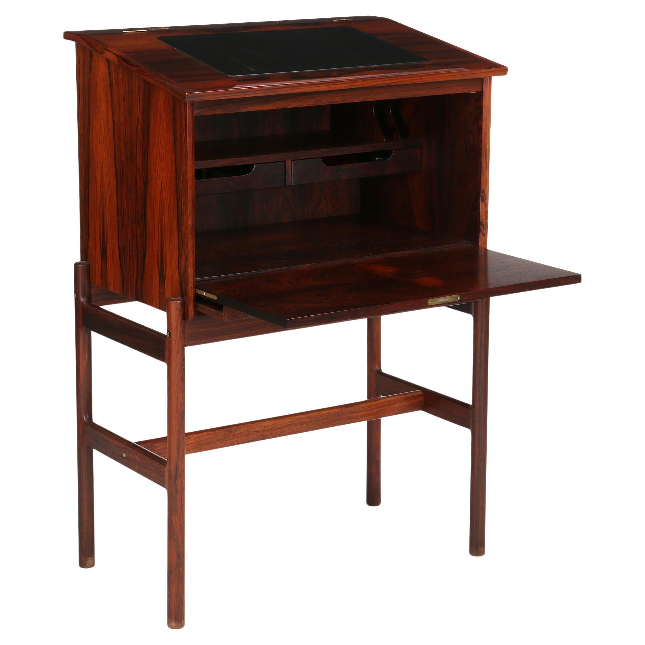 Bureau danois en bois de rose des années 1960 réalisé par un ébéniste. Le nom du chanteur d'opéra Frans Lasson est estampillé au dos de ce pupitre, qui a probablement spécifié les dimensions. Il est intéressant de noter que le style est moderne mais