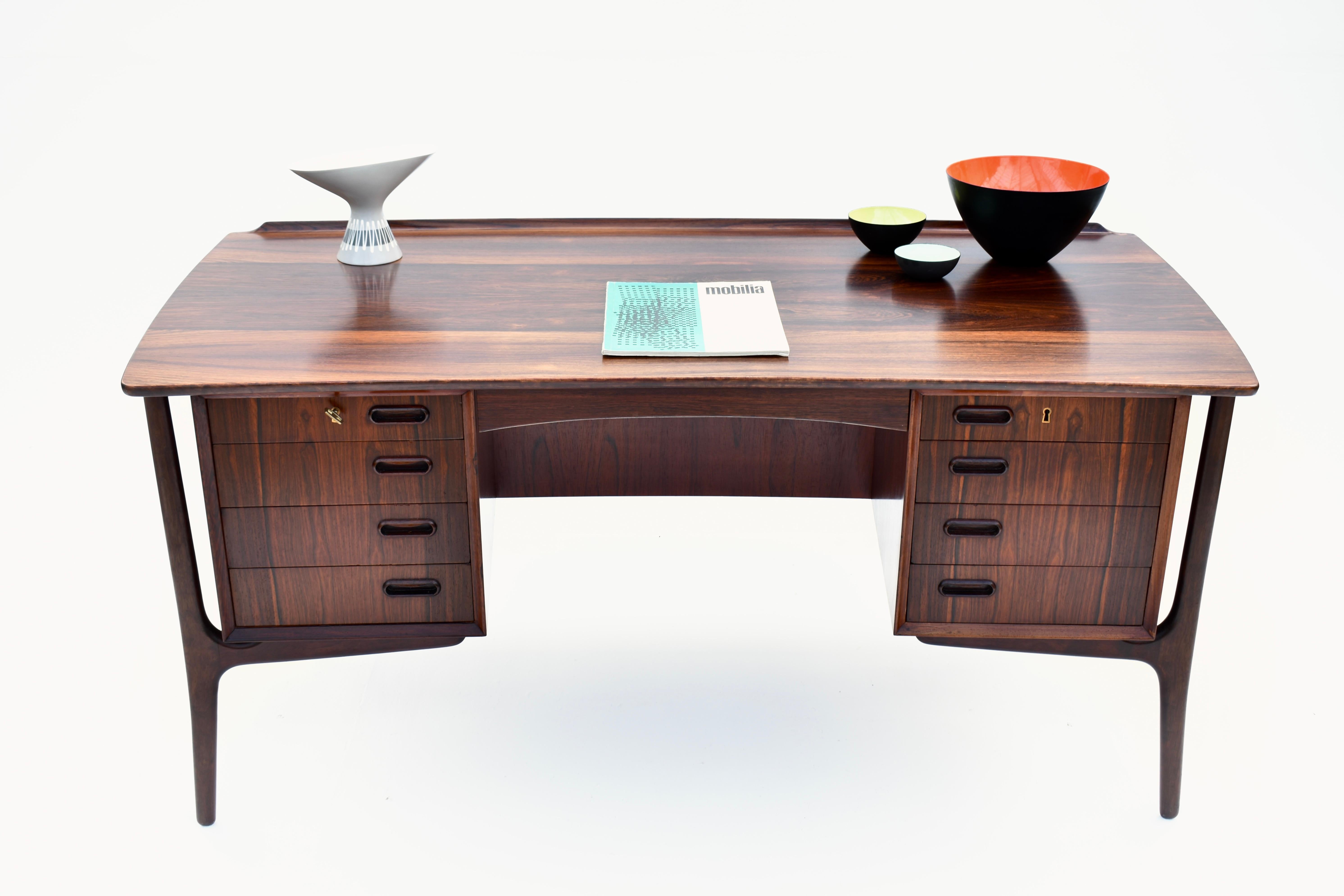Spectacular double pedestal desk of the most elegant design executed in dramatic Brazilian rosewood. Featuring a beautiful curved desktop that wraps itself towards the sitter. To the opposite side of the surface a raised fin. Slender sculptural legs