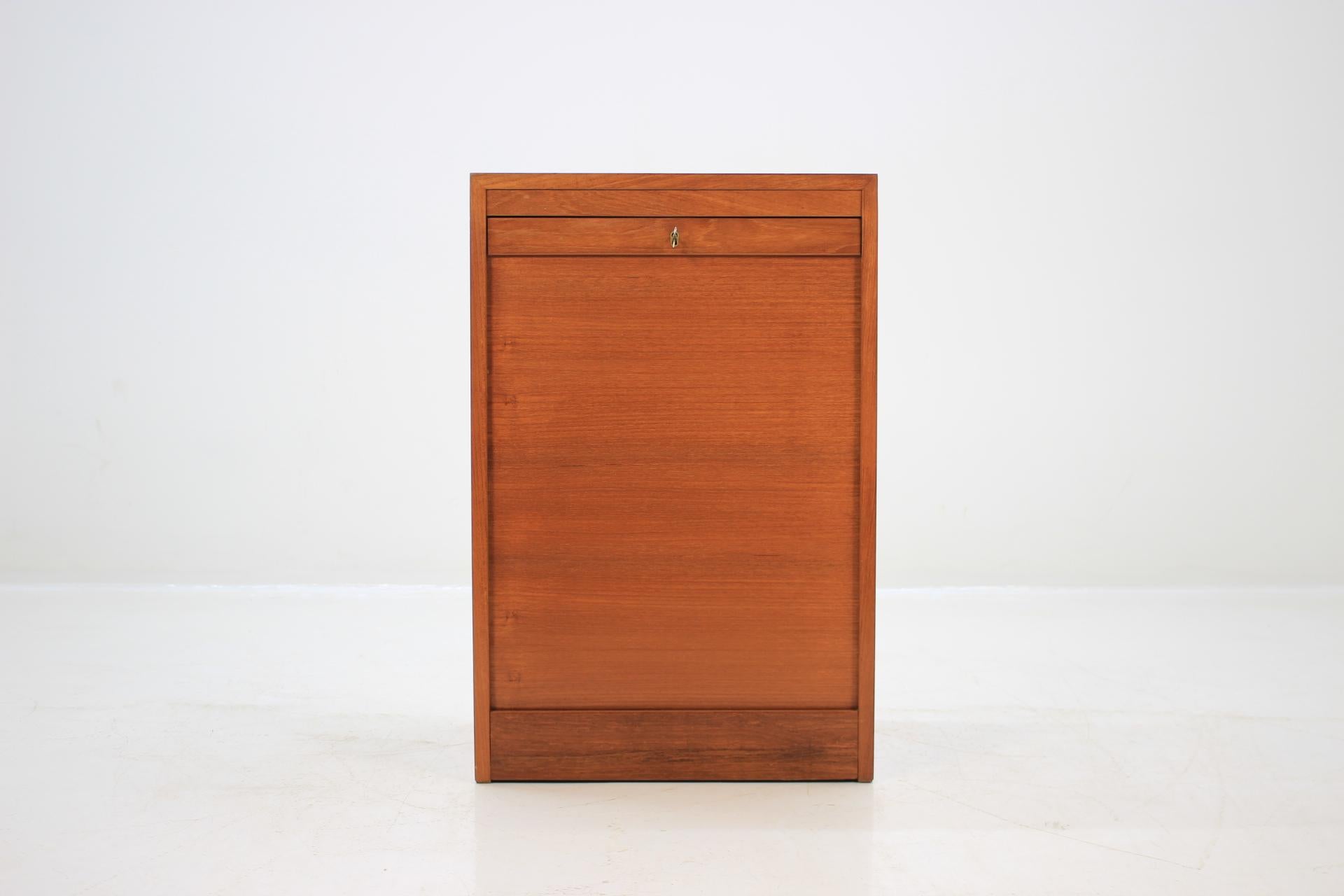 This cabinet features tambour sliding doors with inner drawers. This item was carefully restored.