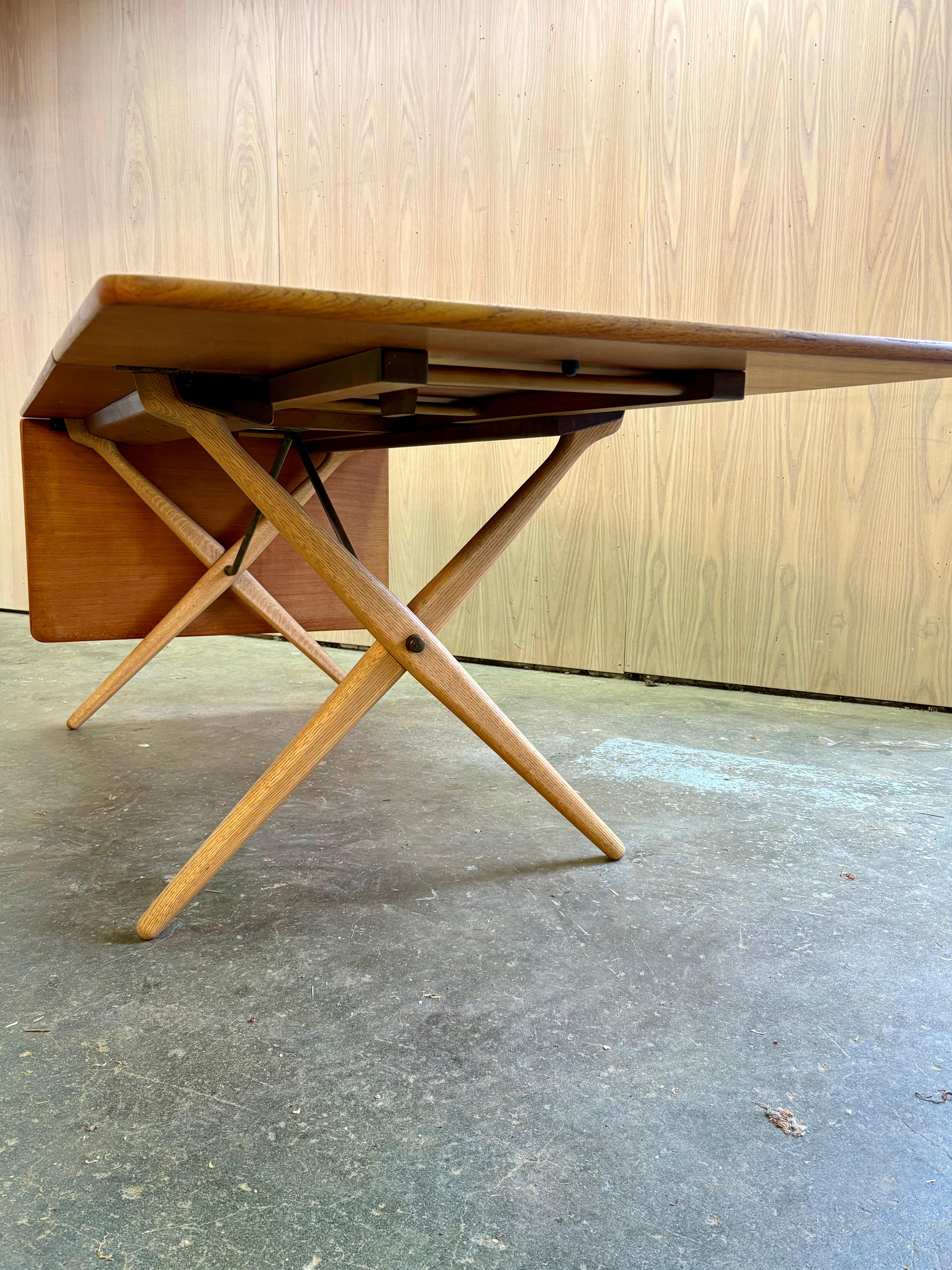 A rare 1960s Danish teak and oak AT-309 dining table by Hans J. Wegner for Andreas Tuck, showcasing the designer’s hallmark blend of sculptural clarity and everyday functionality. The light oak X-frame base pairs beautifully with the warm teak top,