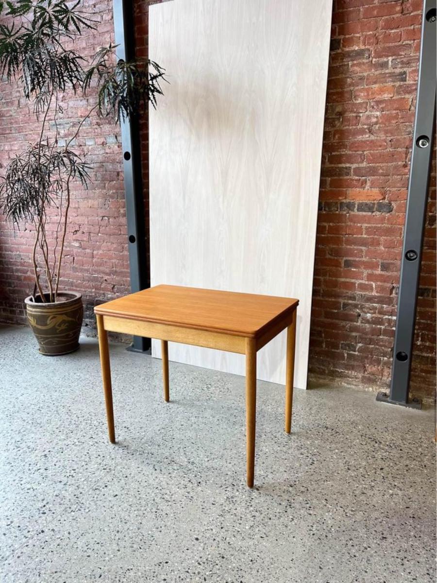 Rare and coveted, this compact desk/dining table by Hans Wegner for Andreas Tuck, circa 1960s, embodies the essence of mid-century modern charm. Crafted with precision, it boasts a sturdy European white oak base and a stunning teak veneer surface.