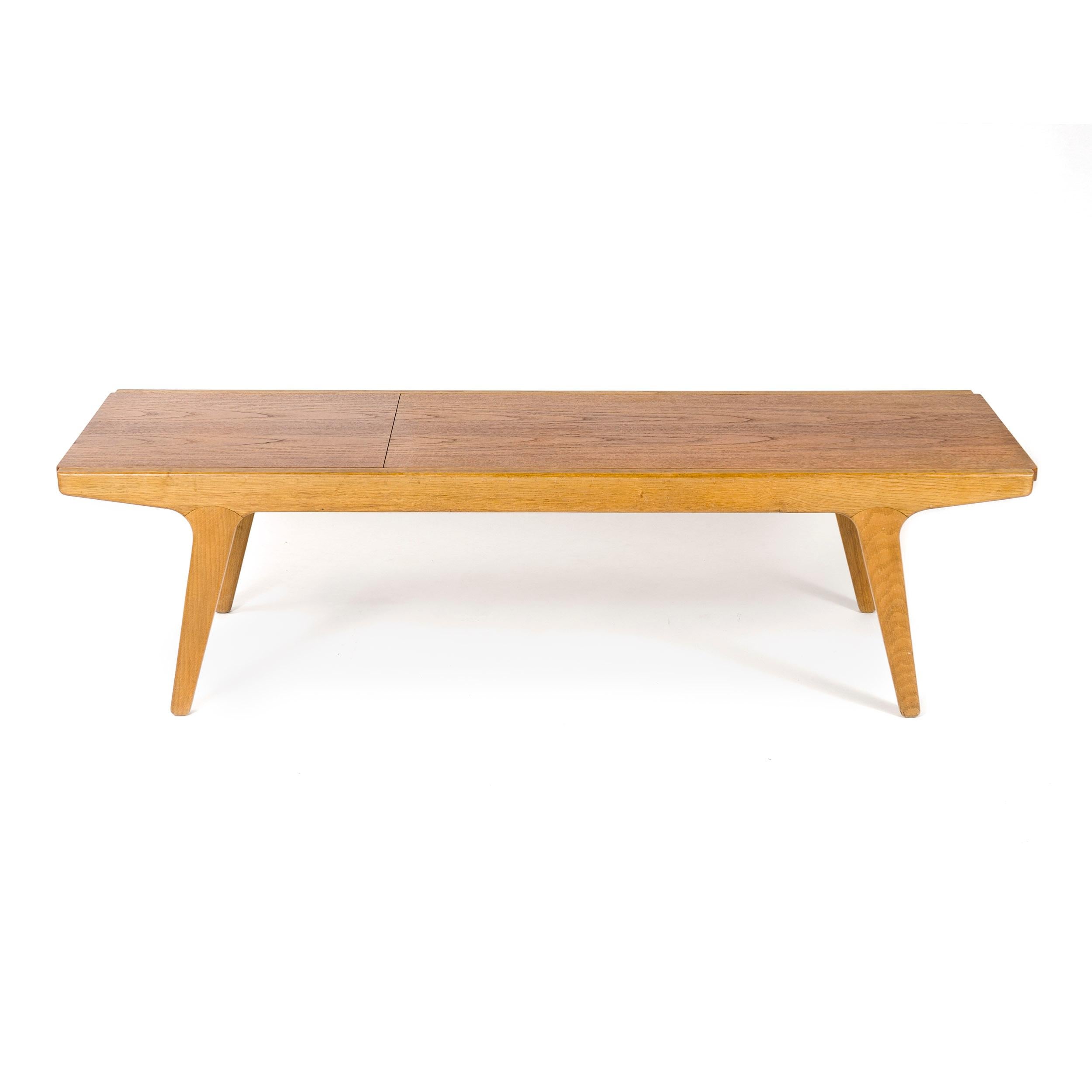 a Danish cabinetmaker quality bench made of oak with a reversible top. the two section top slides on nylon rails built into the frame, the 2 sections slide out from each end of the frame. one side is finished in oiled teak, the opposite side is