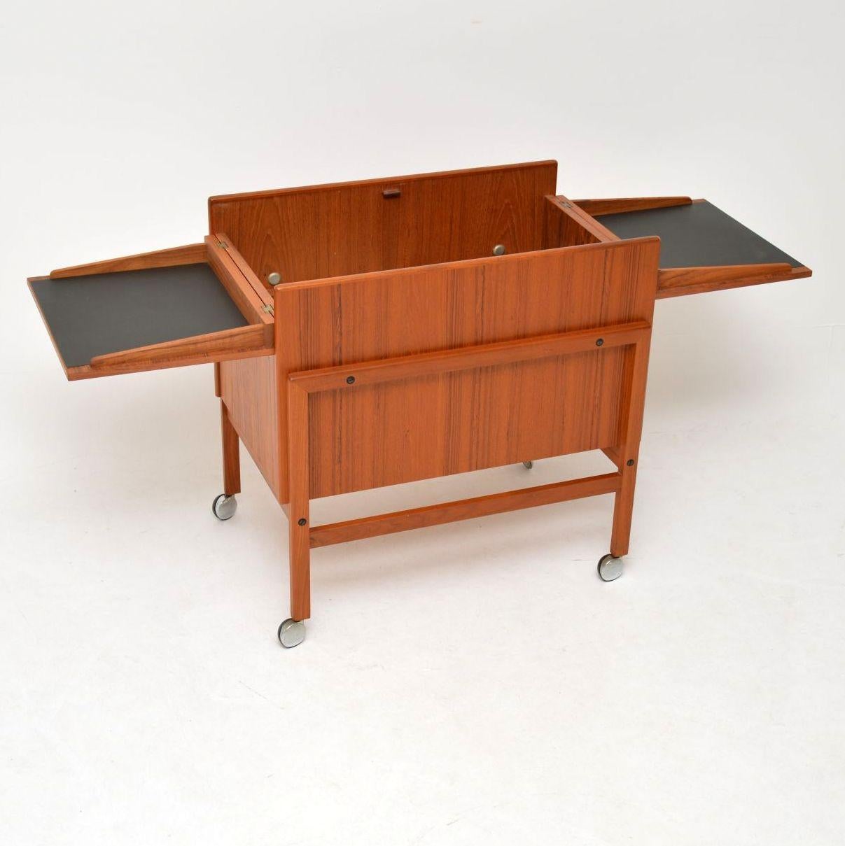 A beautifully designed Danish dry bar in teak, this was designed by Andreas Hansen and was made by Arrebo Mobler in the 1960s. This is in excellent condition throughout, its clean, sturdy and sound, with barely any wear to be seen. The top opens out